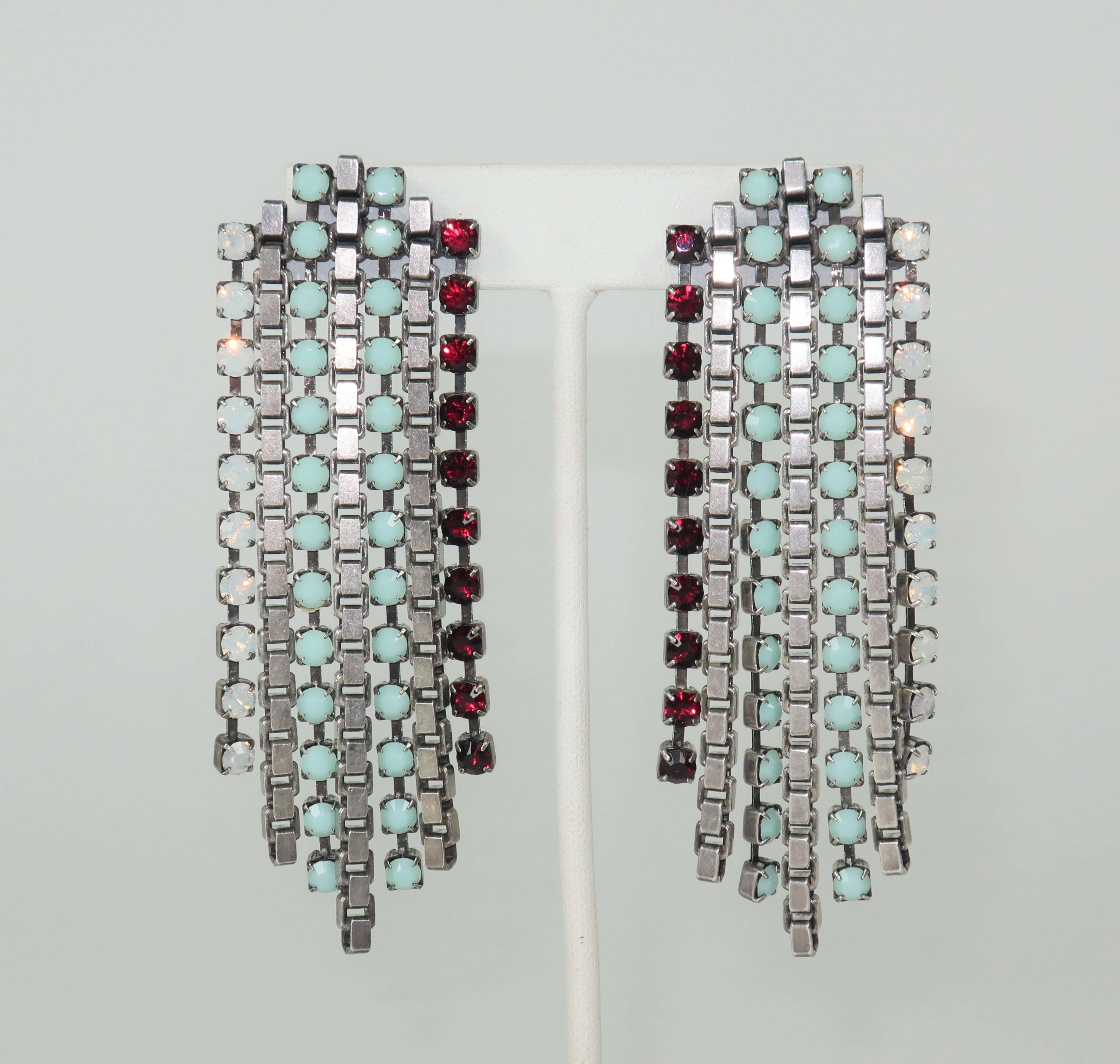 These pierced earrings by Dana Lorenz for her line, Fallon, are a stylish combination of glam and industrial aesthetics.  The waterfall silhouette is created by strands of dangling silver tone box chain interspersed with garnet, mint green and opal