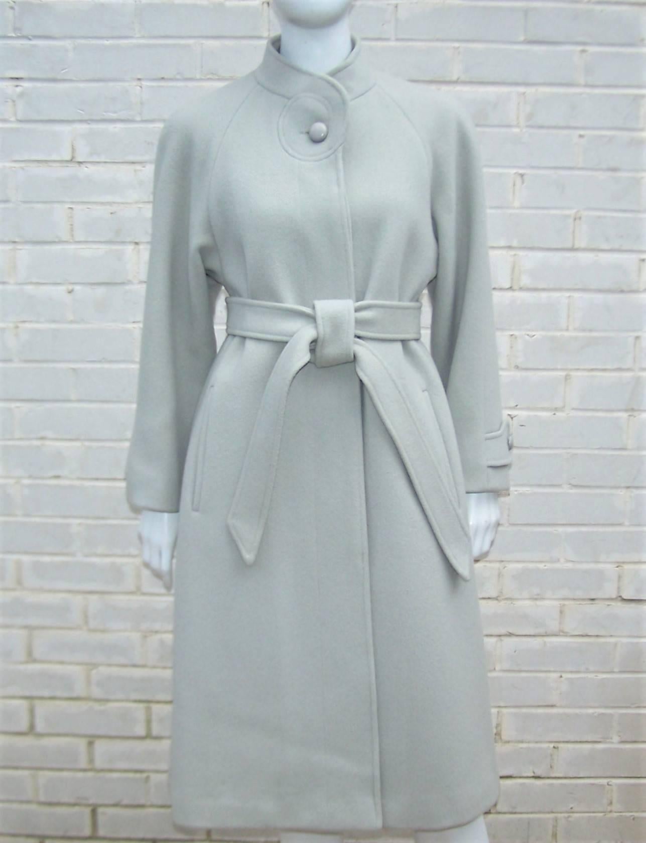 Zandra Rhodes' interest in organic forms is at play in the stylized details of this C.1980 light gray wool overcoat for Green & Makofsky.  The cozy design has hidden buttons at the front with a swirled detail at the mandarin style collar which is
