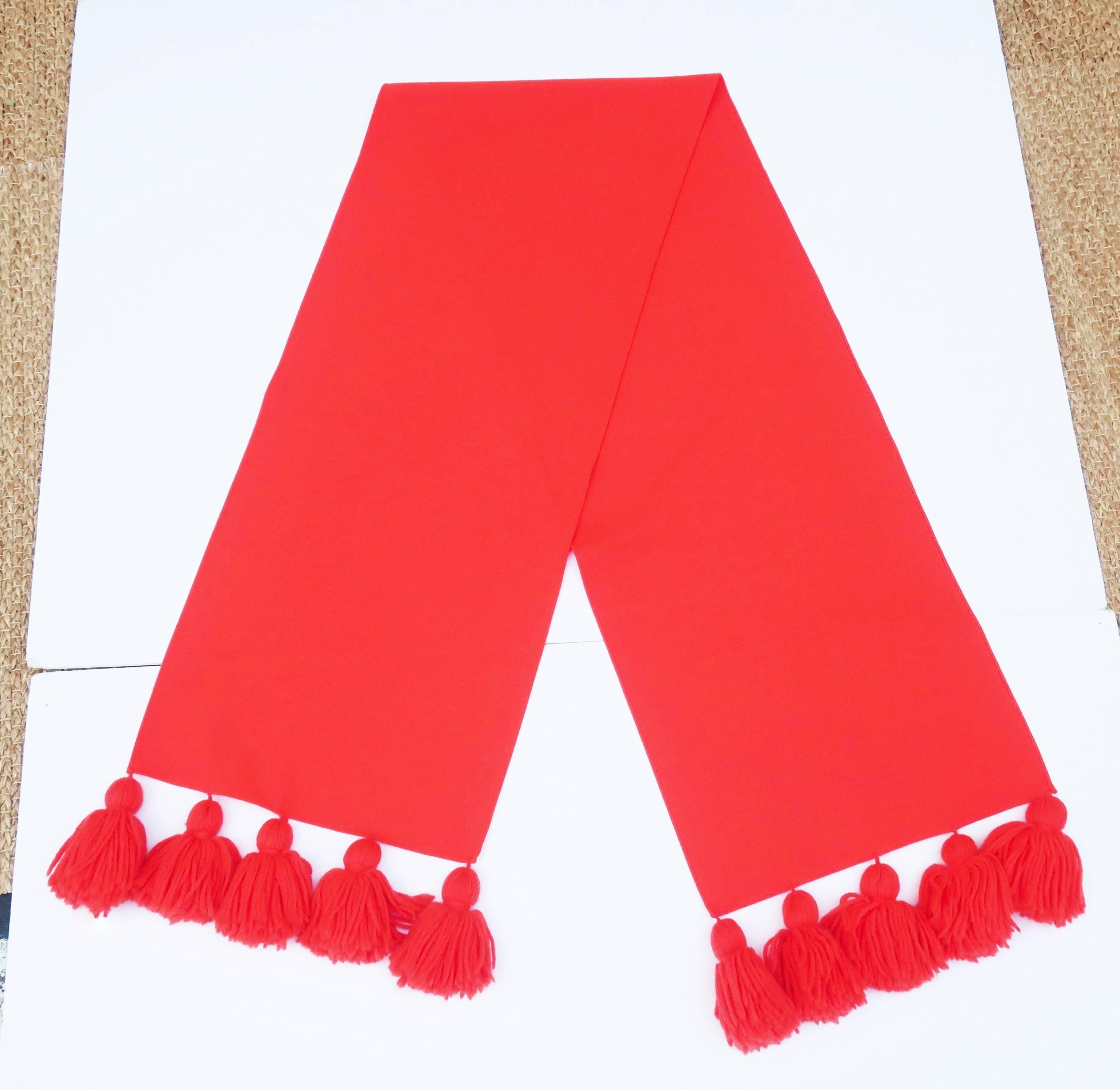 Get ready for some traffic stopping color!  Pair this extra long wool blend red scarf with your winter wardrobe for a fun color pop.  The 68" long scarf is embellished at each end with coordinating 5" long yarn pom poms for a total of