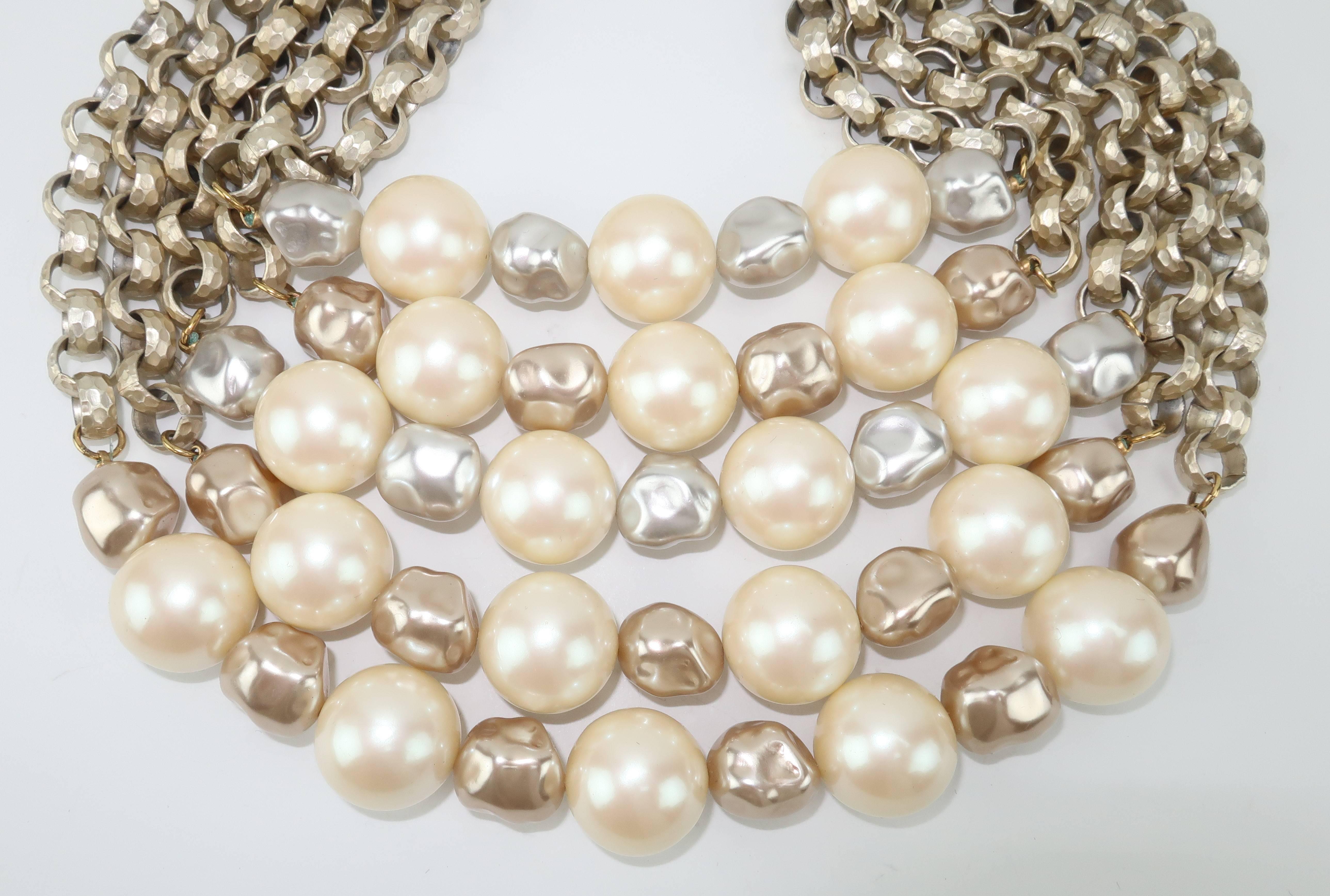 Stunning & stylish!  This Yves Saint Laurent multi-strand necklace is resplendent with three shades of opulent faux pearls suspended by hammered silver tone metal links.  The combination of the pearls and the metal set this multi-strand apart from