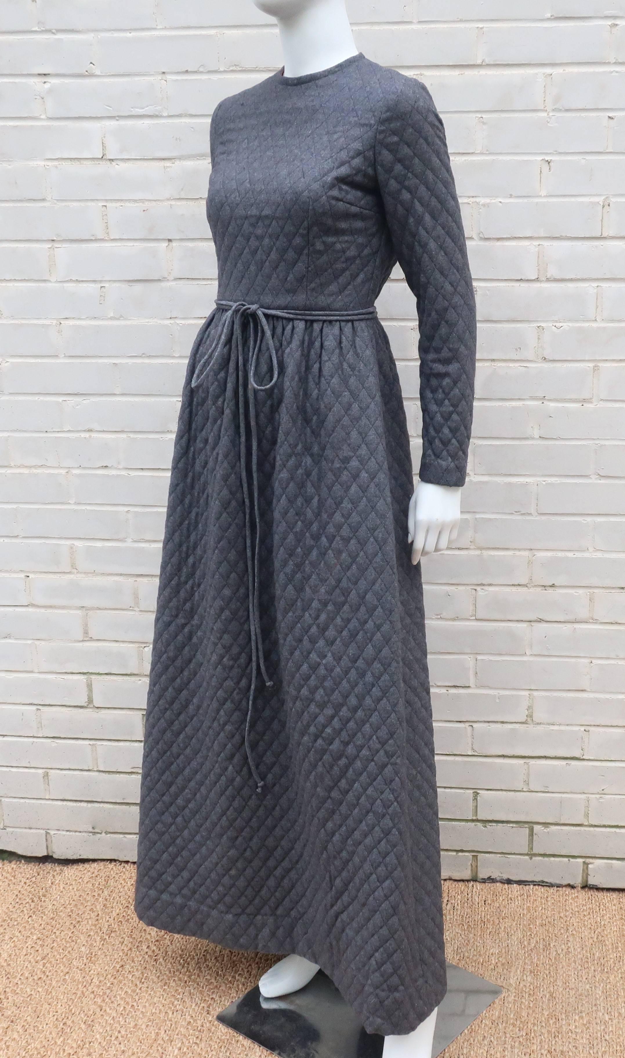 This C.1970 dress by Anne Fogarty conjures up images of Jane Eyre and other heroines of gothic literature.  The austere silhouette is formed with charcoal gray quilted wool fabric in a strict bodice with long sleeves, cinched waist, hidden side