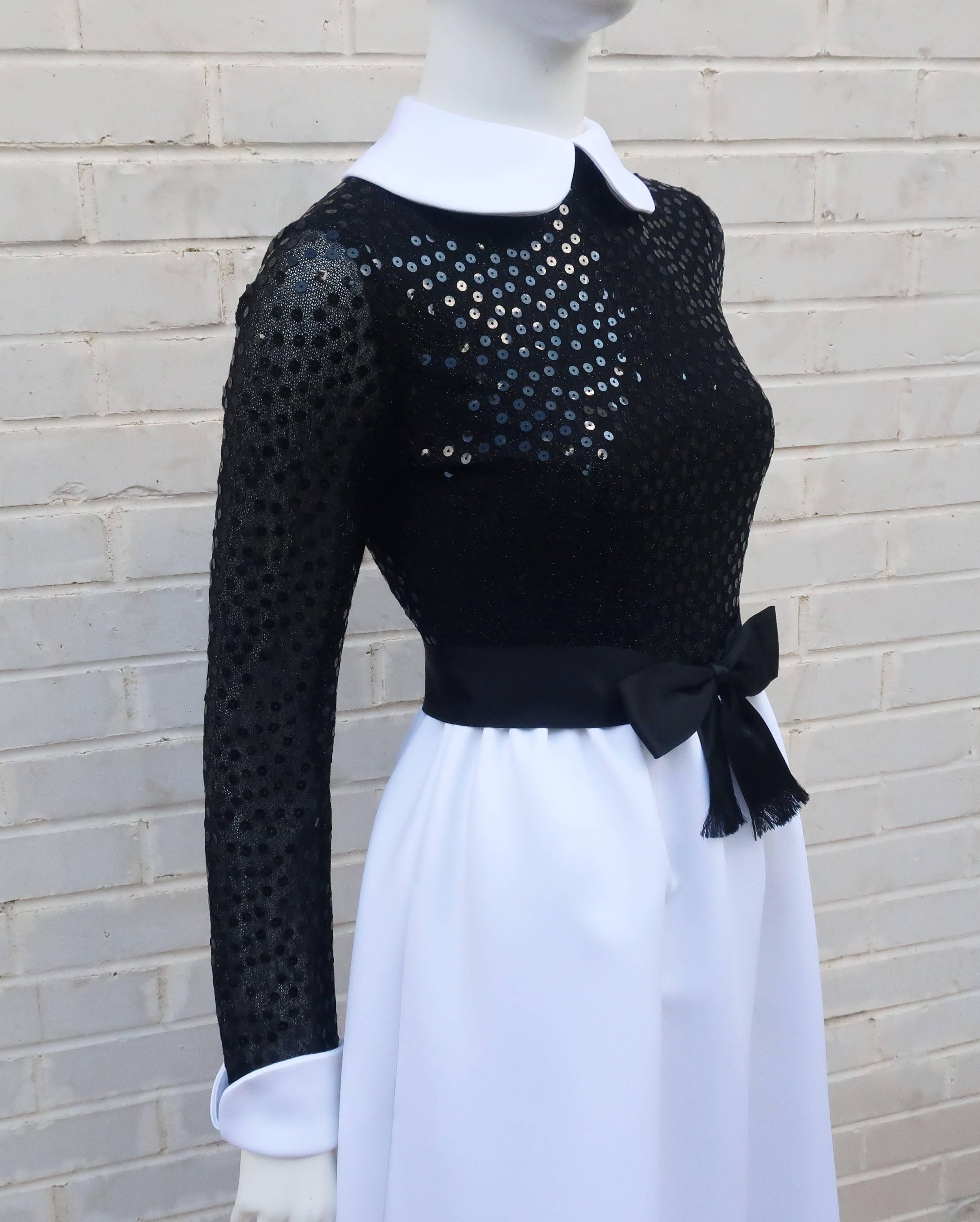 Delightfully demure with a good dose of style and sophistication ... all hallmarks of this 1970's Mollie Parnis evening gown.  The dress zips and hooks at the back with a built-in black satin bow belt and Peter Pan collar.  The bodice is a black