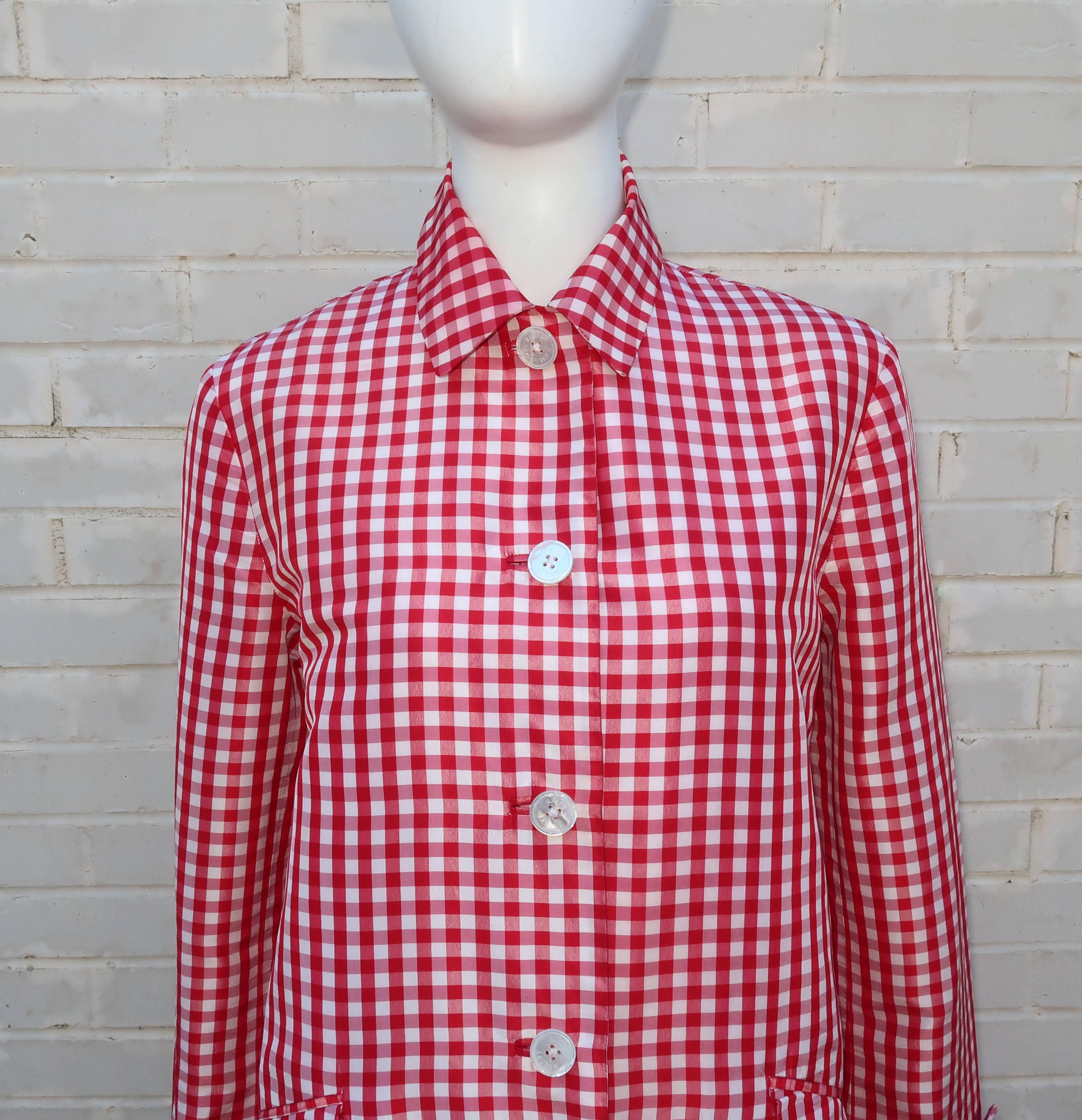 Crisp all-American good looks abound in this 1990's silk red & white gingham topper with trench coat styling by Ralph Lauren.  The coat buttons at the front with flap front pockets and cuff details.  The large mother-of-pearl buttons are logo