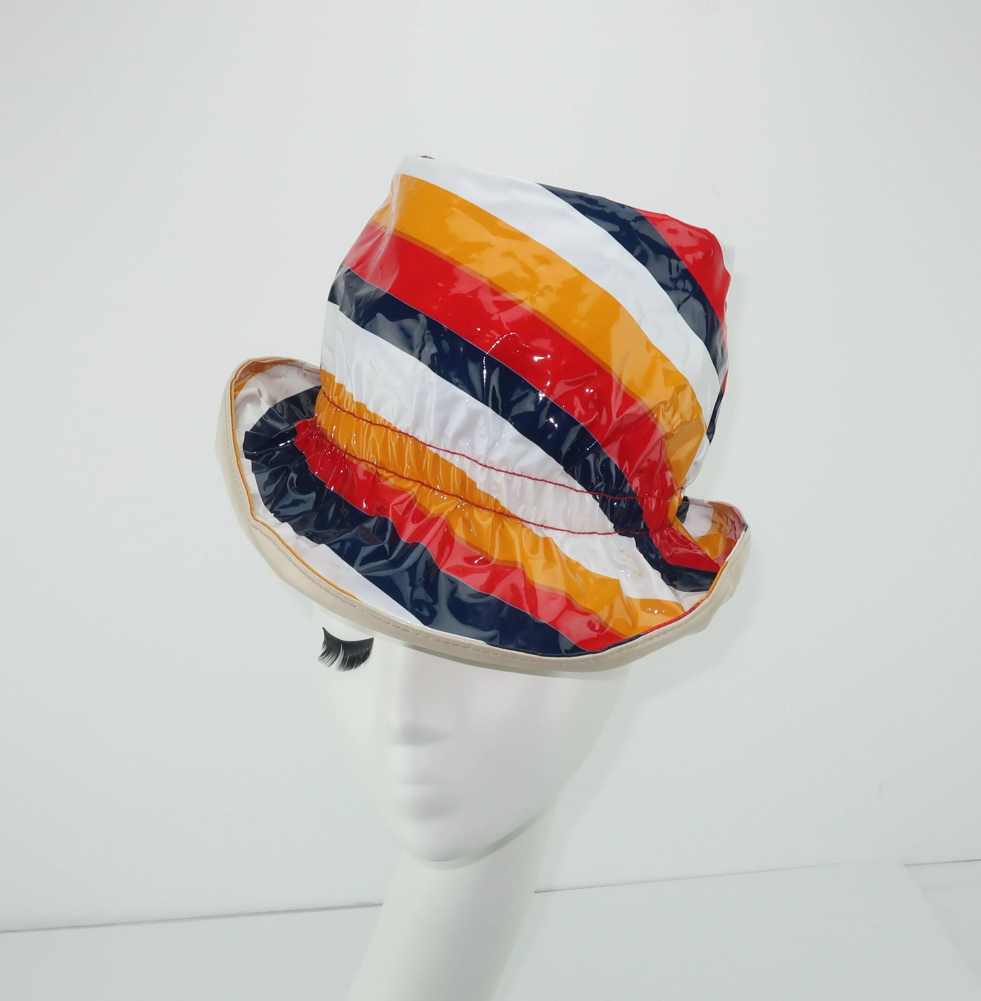 Love it!  This fun plastic hat puts sunshine and a smile into a rainy day.  The pop mod striped hard plastic shell incorporates red, white, blue and yellow colors with a bone shaded vinyl lining.  Practical for an inclement day but it is really just