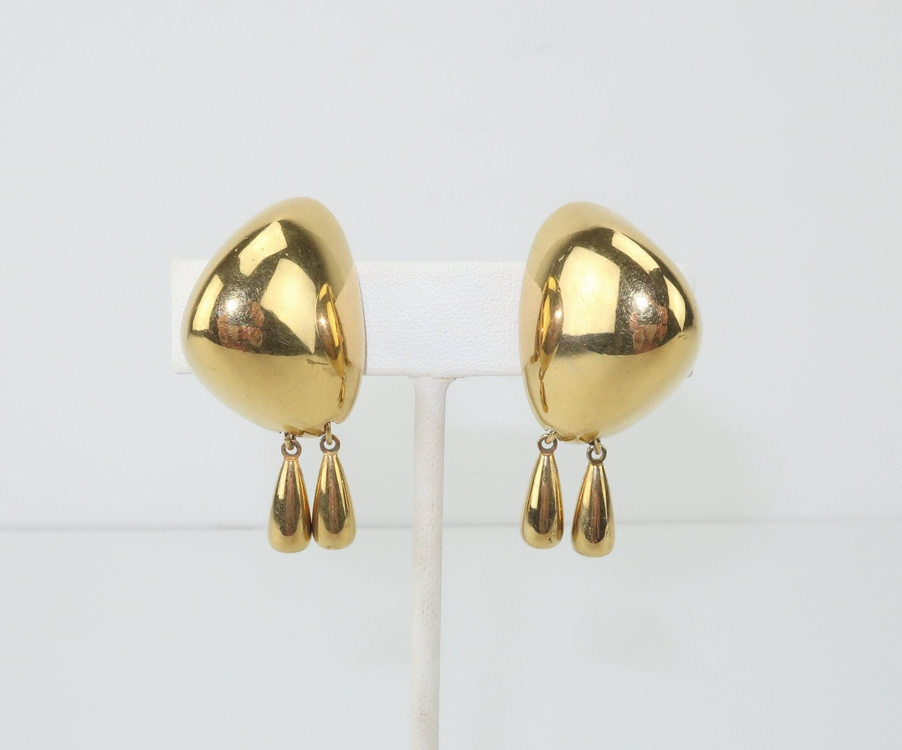 The modernist silhouette of these stylish Liz Claiborne earrings are a testament to good design.  The boulder shaped domed body of the gold tone clip on base suspends two dangles providing movement and a look equally at home with casual or