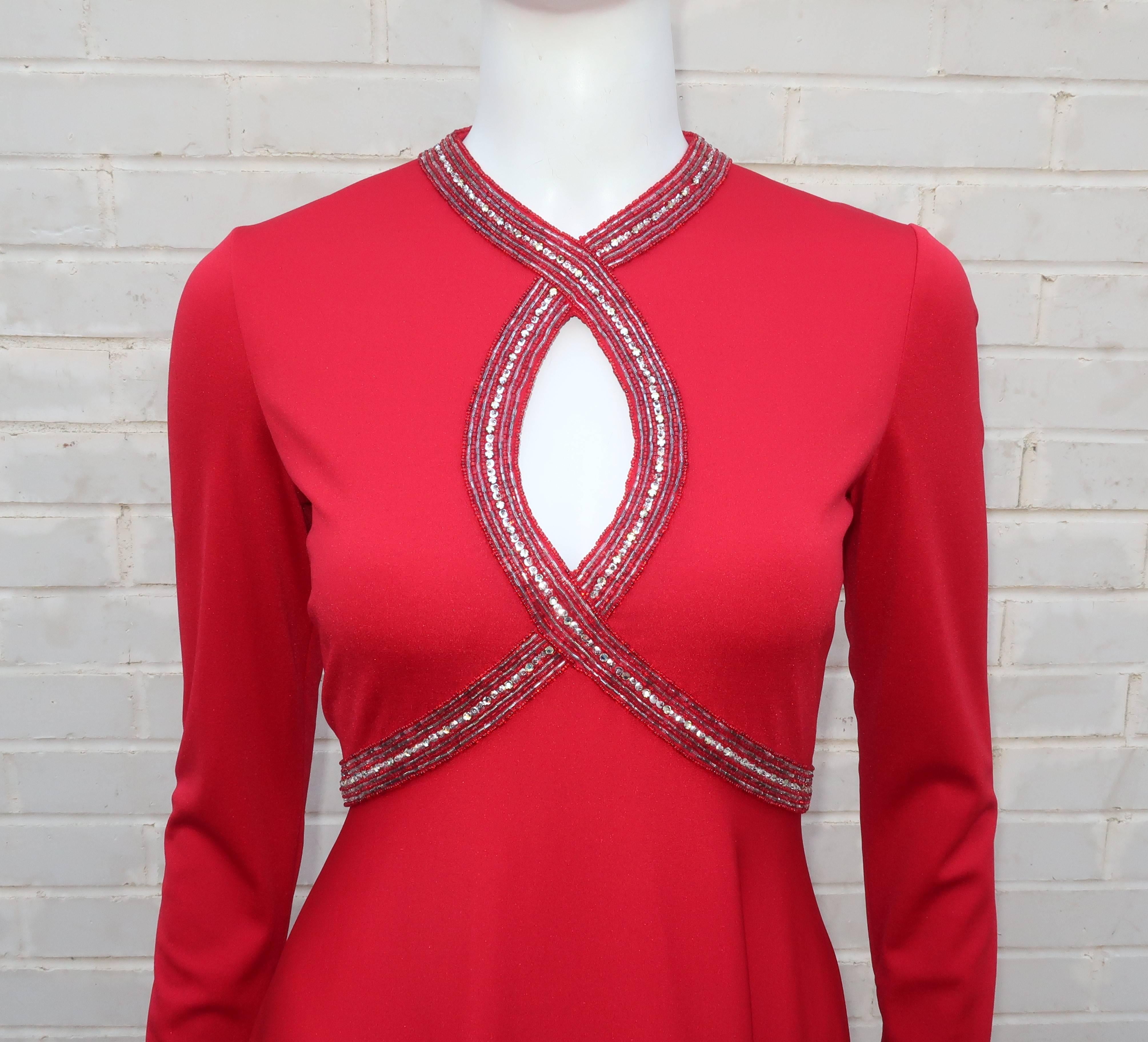 Cut a slinky, yet elegant, silhouette with this C.1970 Victoria Royal evening dress.  The bright lipstick red jersey sports a flattering a-line skirt topped by a fitted bodice embellished with a beaded, sequined and rhinestone peek-a-boo neckline. 