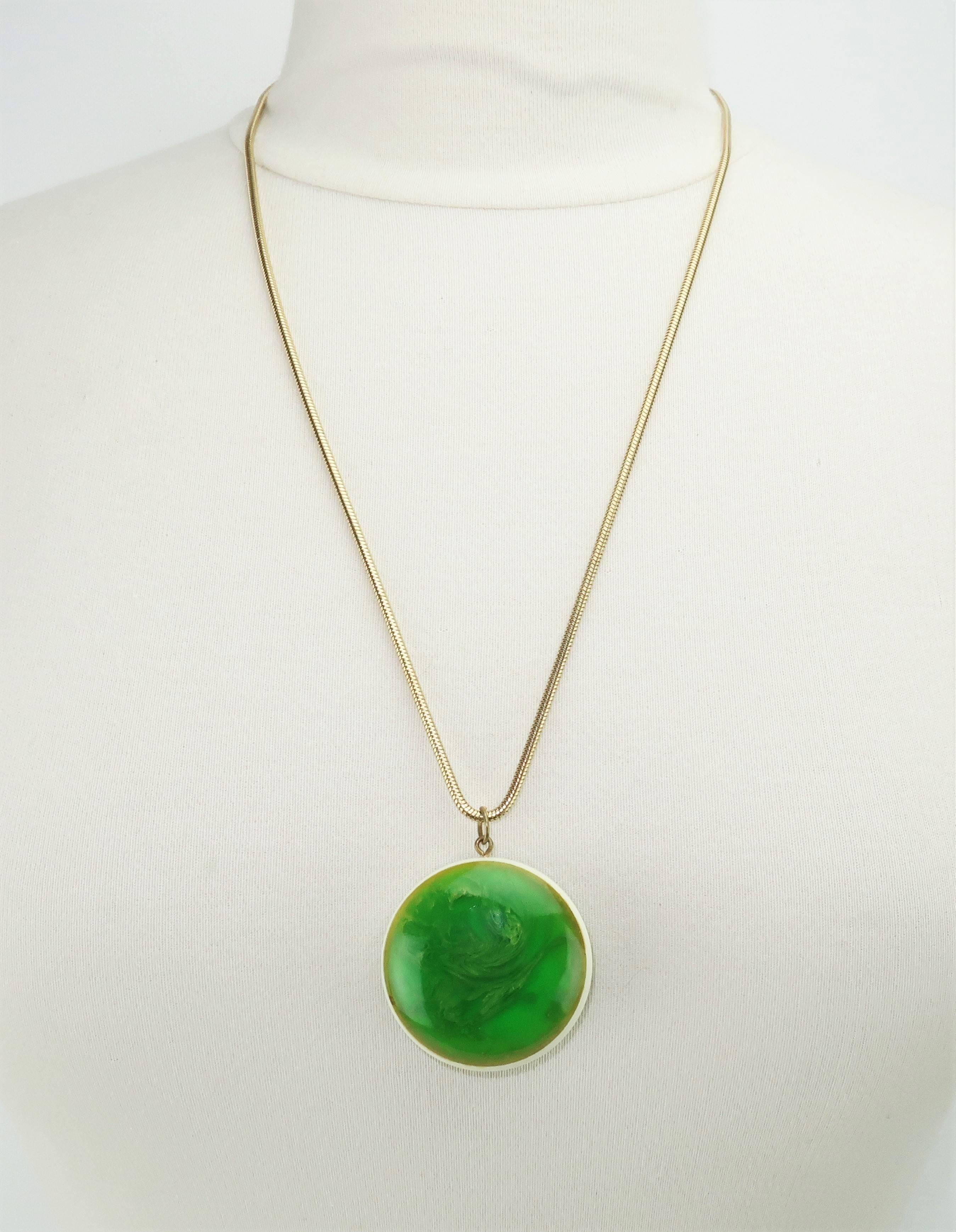 This mod acrylic pendant is a delightful miniature world of emerald green swirls providing a marbleized effect similar to end-of-day bakelite jewelry.  The double sided acrylic is encased by an ivory white edging which sets off the deep colors.  The