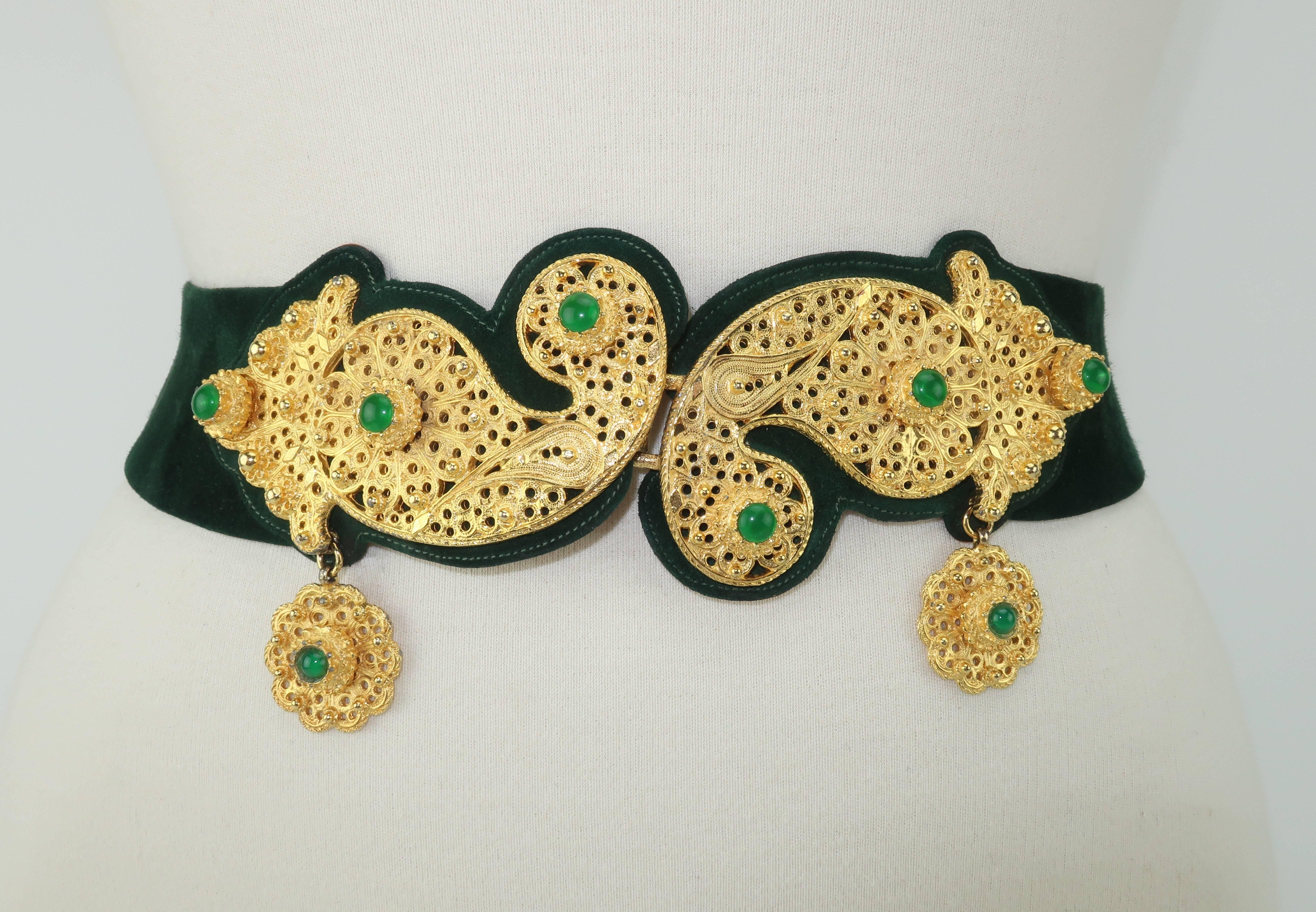 Opulence abounds with this rich Judith Leiber for Saks Fifth Avenue gold filigree green suede belt.  The detailed jewelry style metalwork buckle has an exotic Kashmir type paisley design with faux emerald cabochons and dangling charms.  The buckle