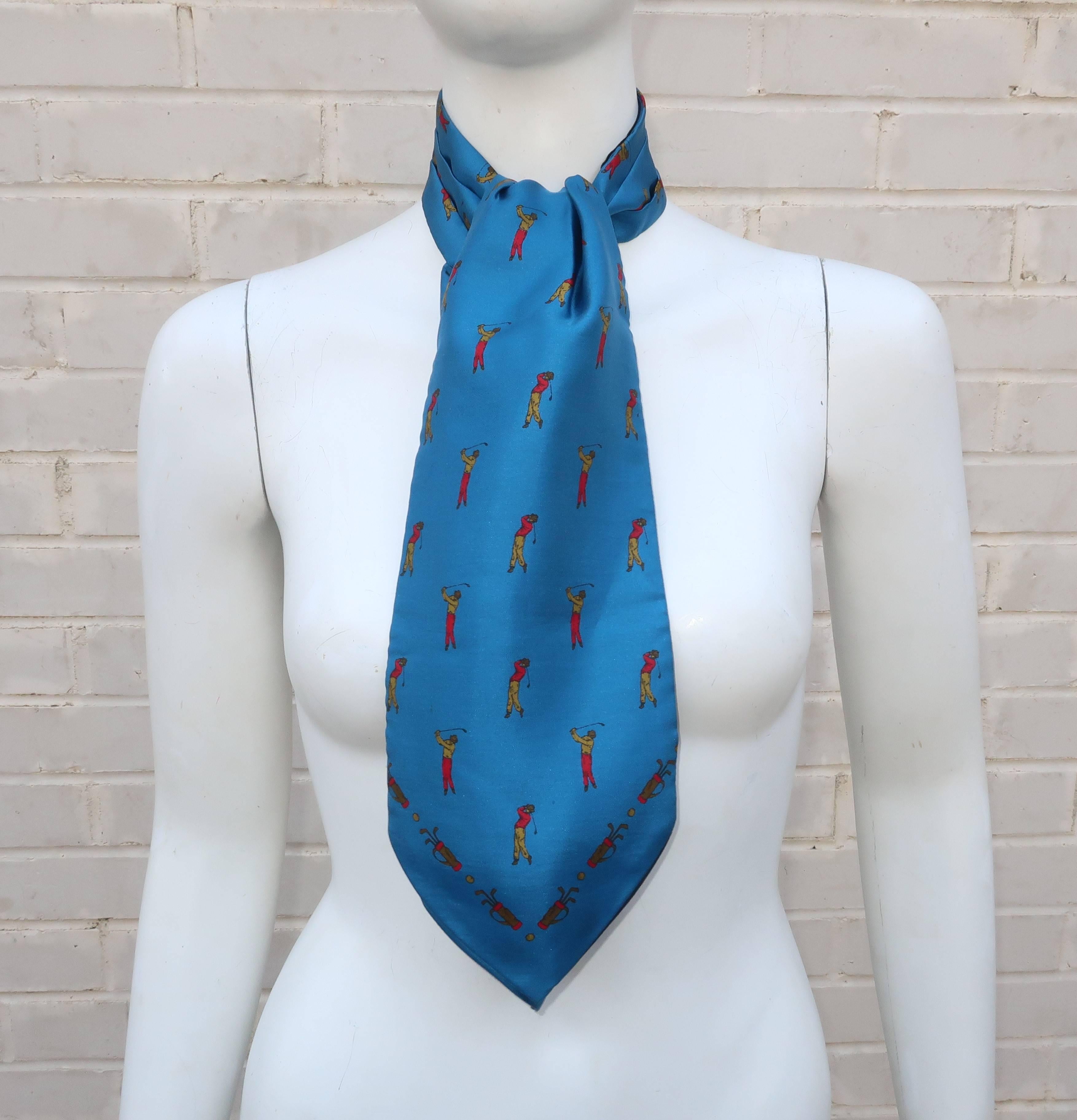 What should every well dressed man wear to the golf course?  An all silk Italian ascot by Ashear, of course!  This reversible ascot tie features golfers, clubs and balls in shades of red, goldenrod, yellow and gray on a brilliant blue background or
