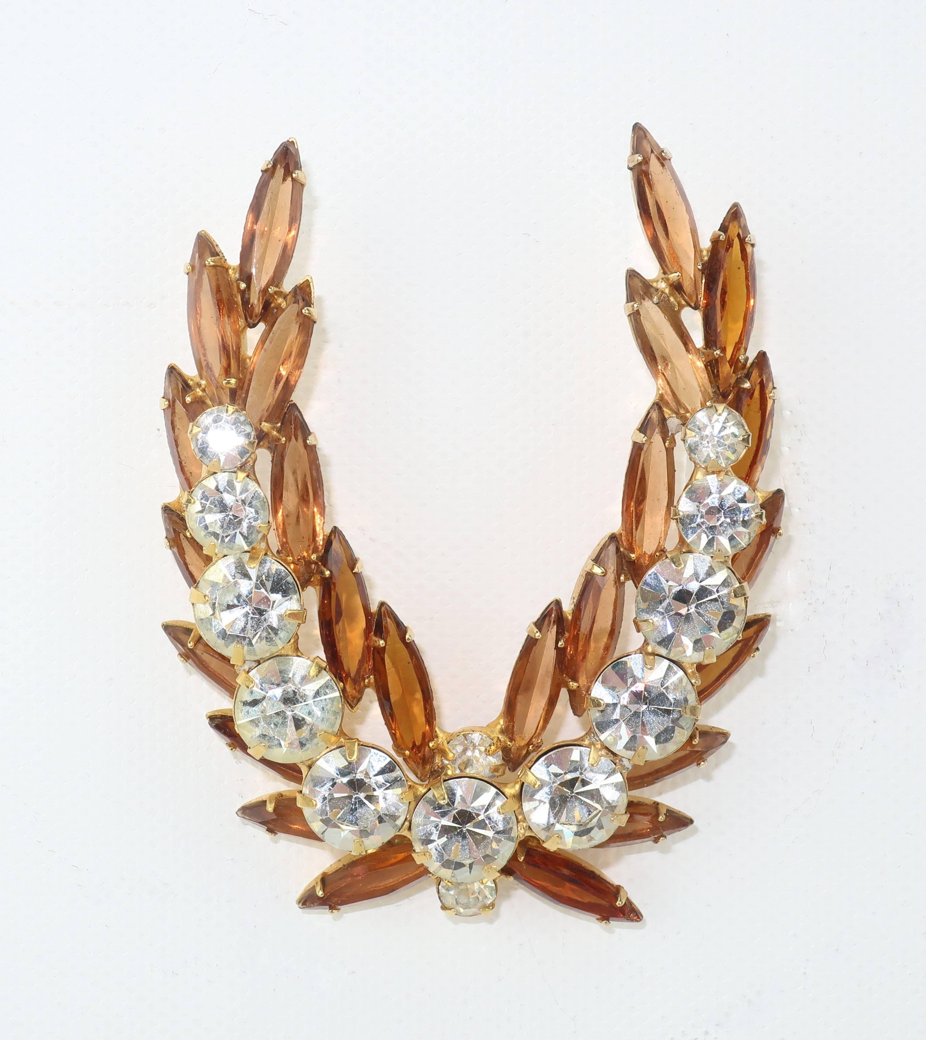 Laurel leaves are a symbol of victory used in ancient Greece to decorate both military heroes and meritorious athletes.  What better way to display your sartorial prowess then with this 1950's rhinestone brooch exclaiming a fun fashion 'win'!  The