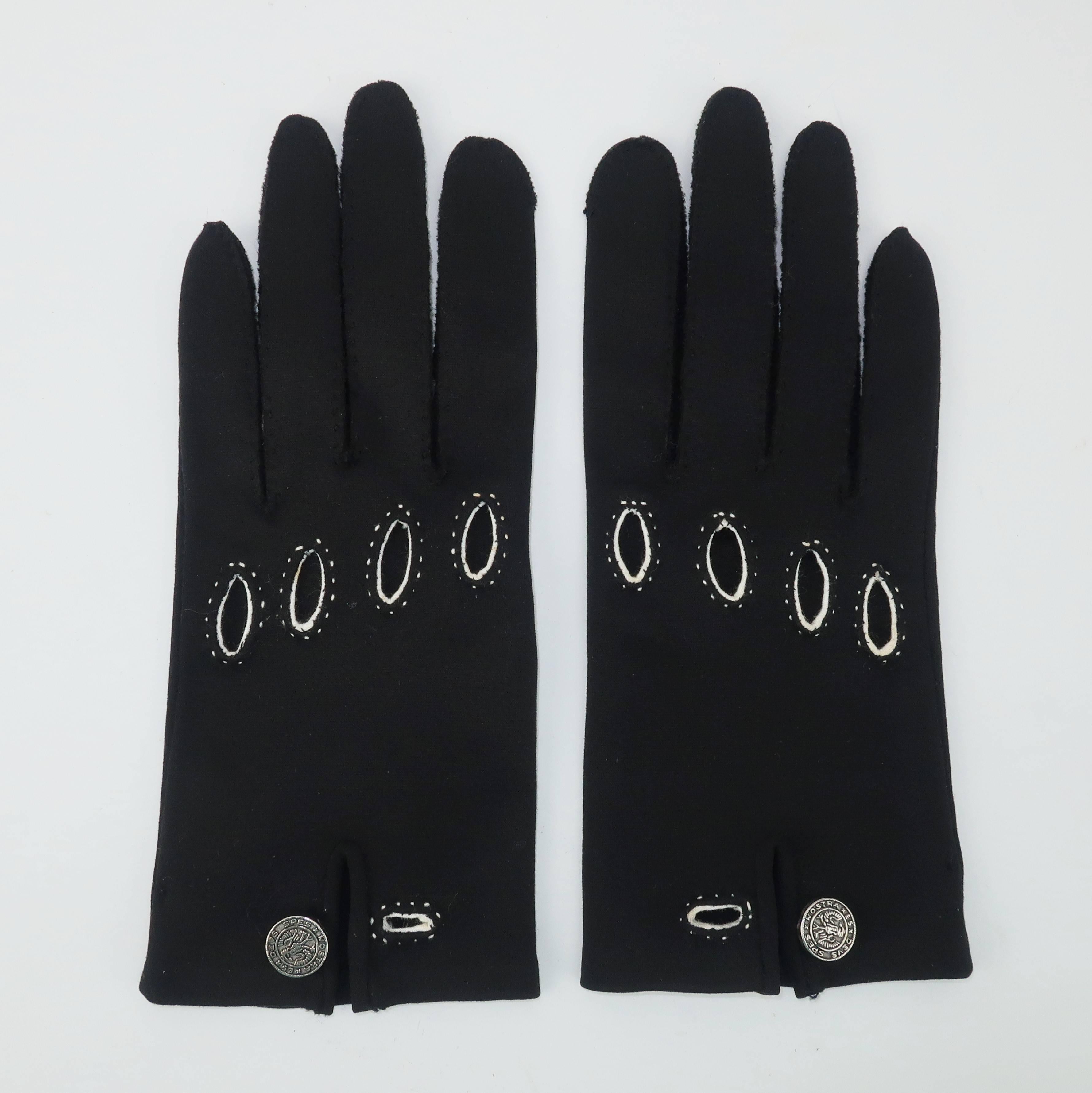 Ces gants Saks Fifth Avenue sont une solution à la mode pour le gant de conduite classique.  Le corps en coton poli noir est rehaussé de surpiqûres blanches aux découpes et au poignet.  Un bouton en métal argenté décore le poignet avec le slogan