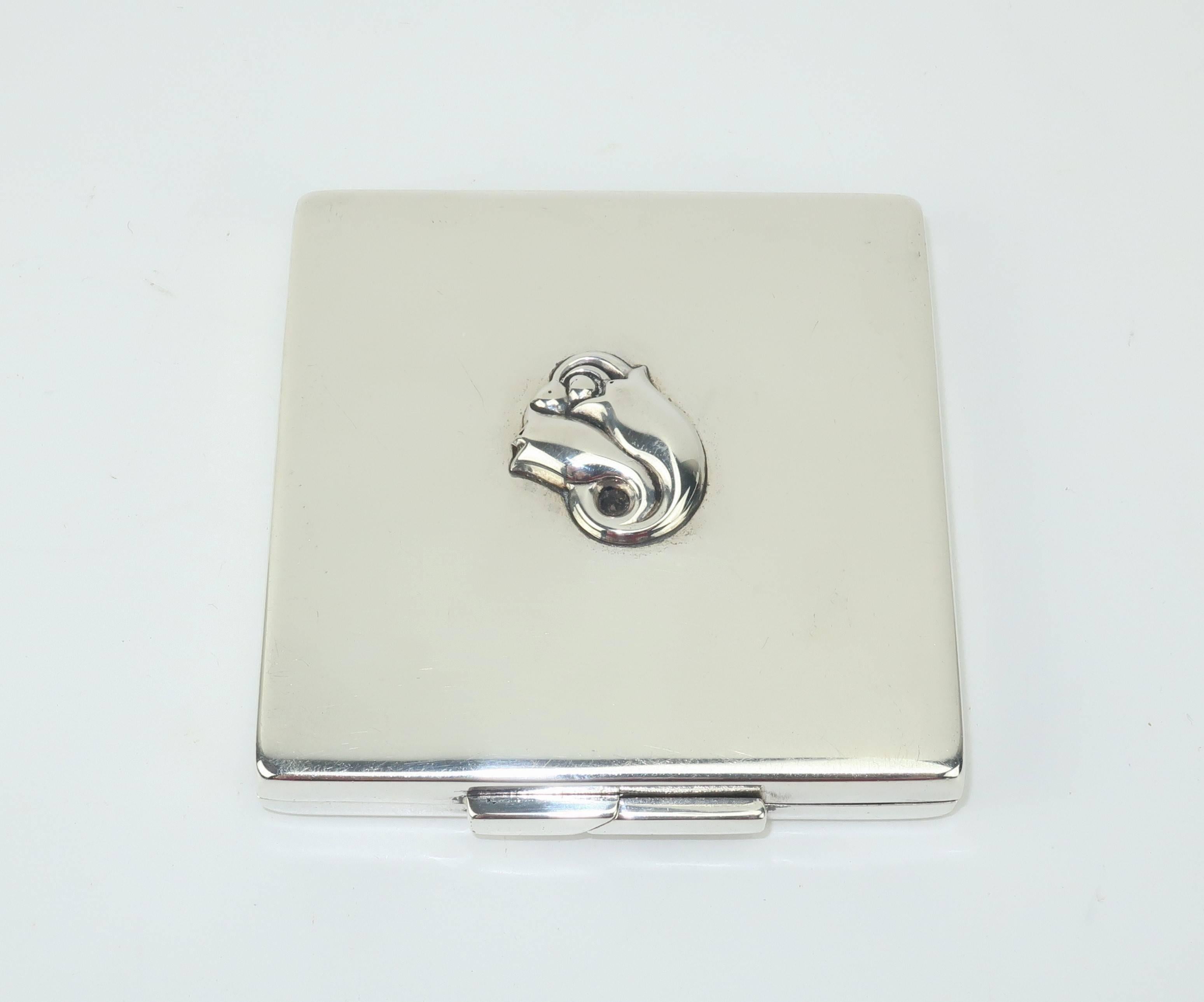 Georg Jensen's name has been synonymous with high quality Danish design in metalwork since the early 1900's.  This sterling silver powder compact is an elegant example of his work with a traditional square form sporting a modernist closure and tulip