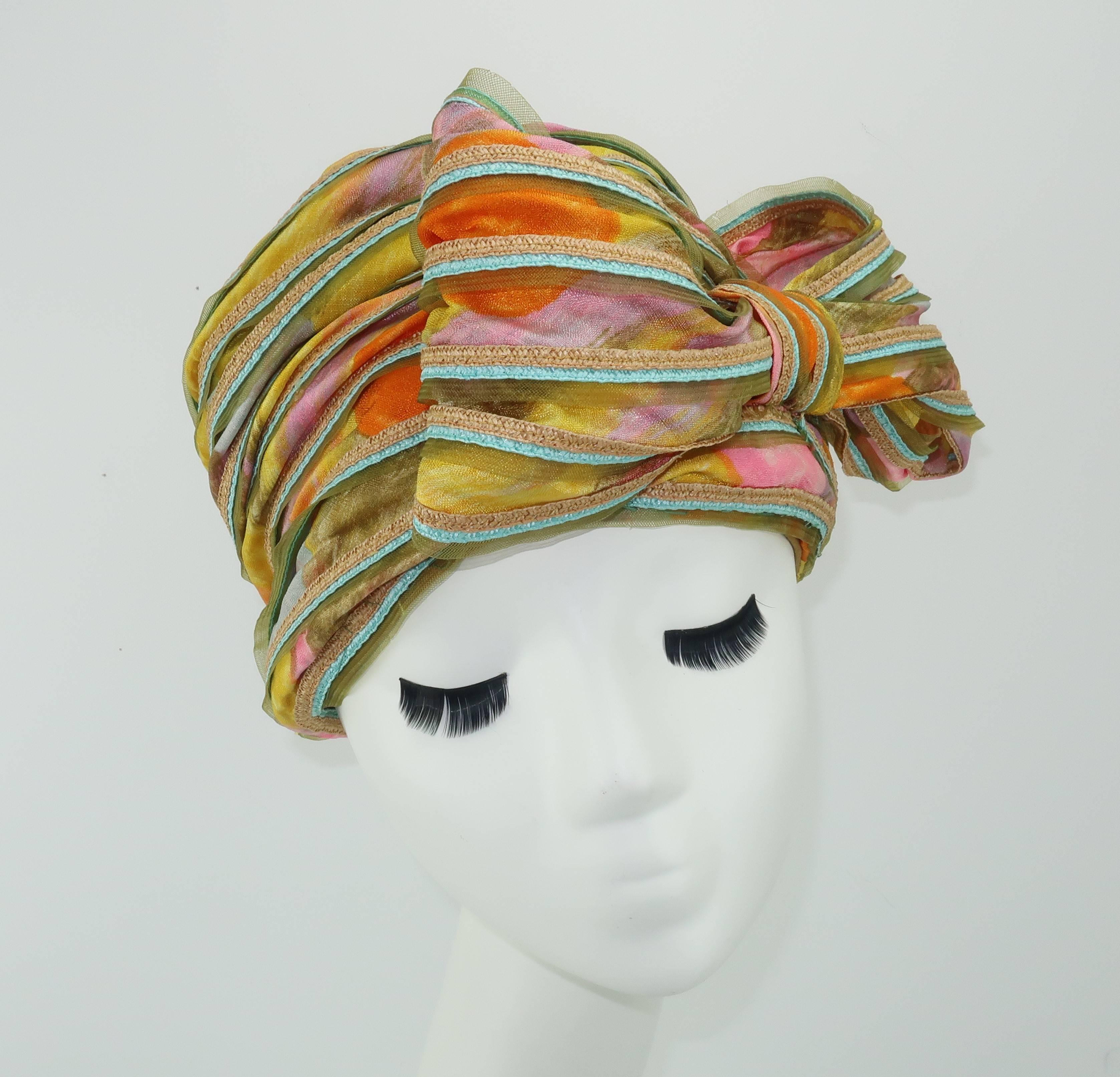 This adorable confectionery hat designed by John Harberger for his millinery line, Mr. John Jr., has a whimsical 1960's aesthetic.  The construction of the hat is quite elaborate and consists of layered pastel floral fabric, natural and aqua blue