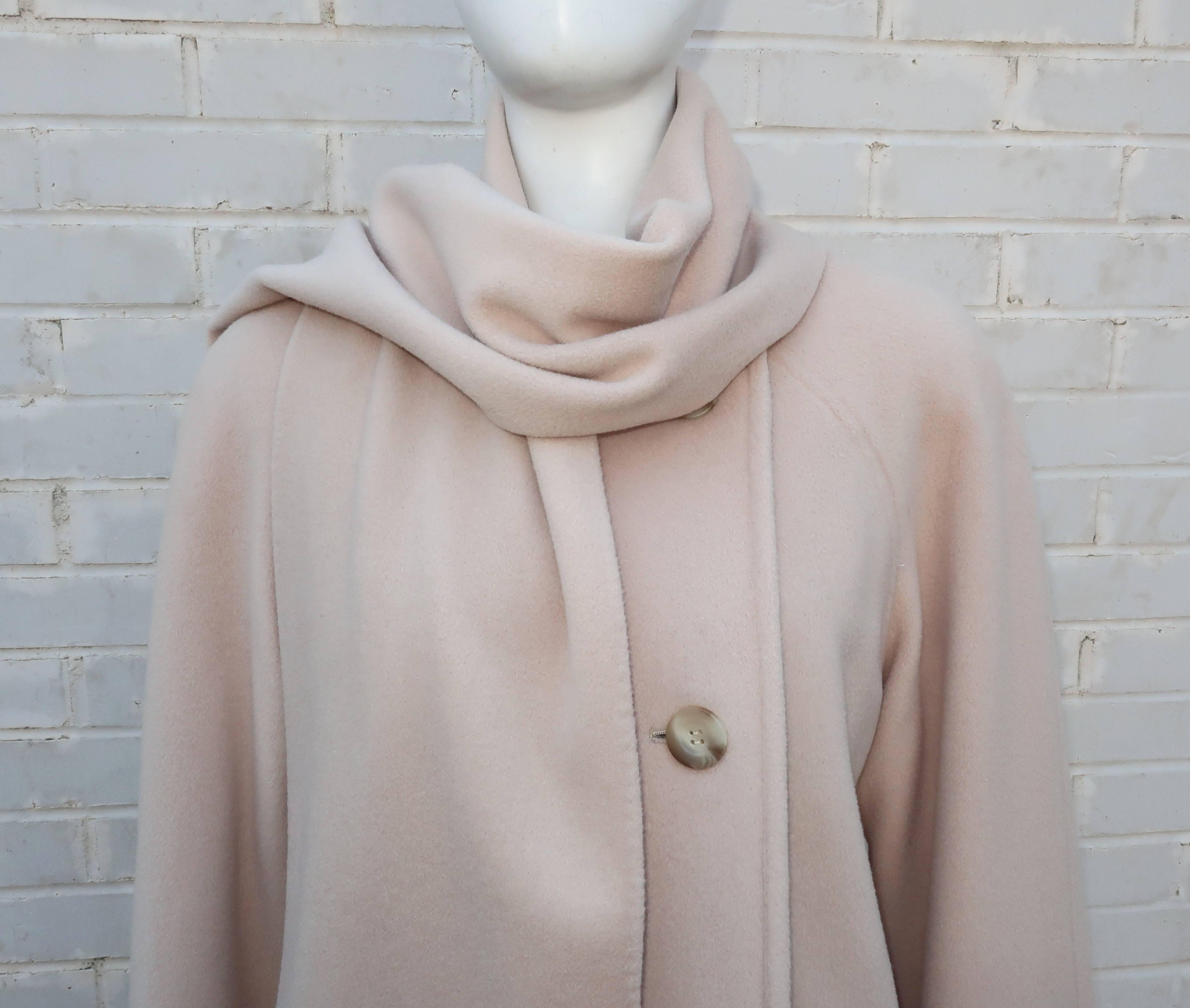 This 1980's Saks Fifth Avenue car coat is a classic combination of cozy cashmere with a stylish silhouette.  The light hued camel color bears just a touch of blush making it the perfect topper to transition into Spring.  It buttons up the side with