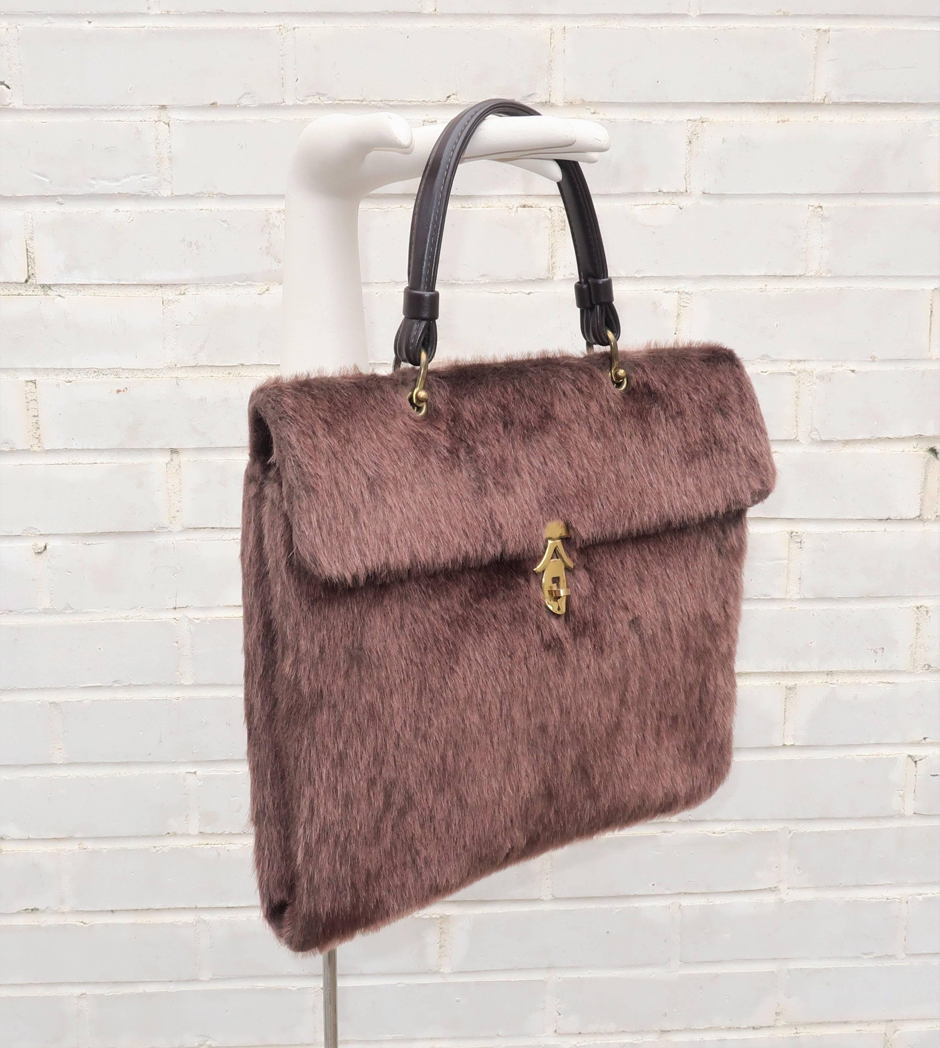Faux fabulous with a wooly mammoth twist!  This fun brown faux fur handbag is a roomy envelope shape with a flap front turn lock closure.  The handle is attached with brass hardware and the interior is lined in vinyl with an open pocket and zippered