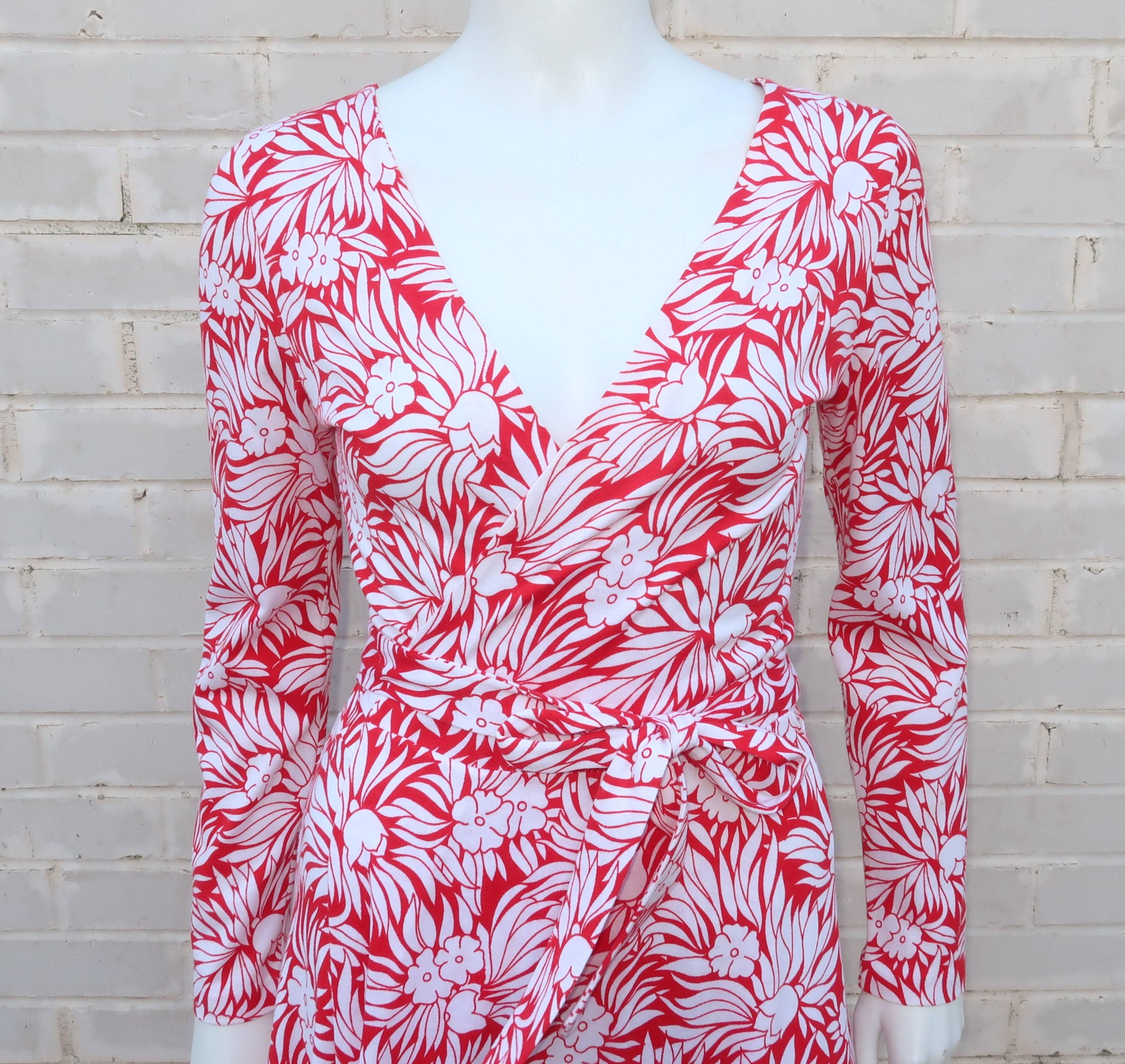 This is an unusual maxi version of Diane Von Furstenberg’s classic wrap dress.  The cotton jersey fabric features a graphic red and white tropical floral print.  The stylish wrap silhouette provides for a sexy plunging neckline and hint of leg with