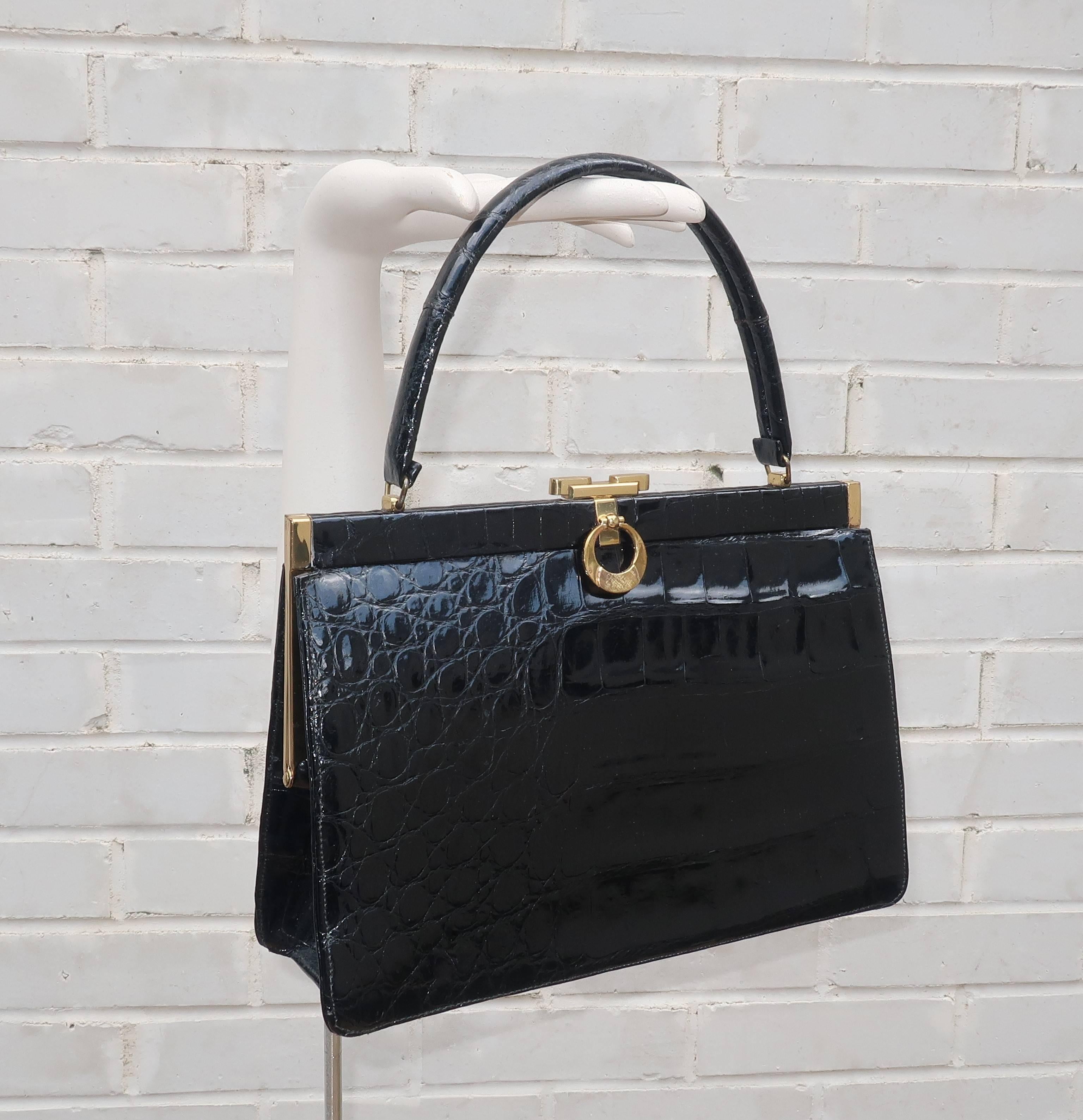 This 1950’s Bellestone black alligator handbag would be perfect for an Alfred Hitchcock heroine ... think Grace Kelly, Tippi Hedren or Kim Novak.  The classic top handle silhouette has a gold tone frame with a push button closure accented with a
