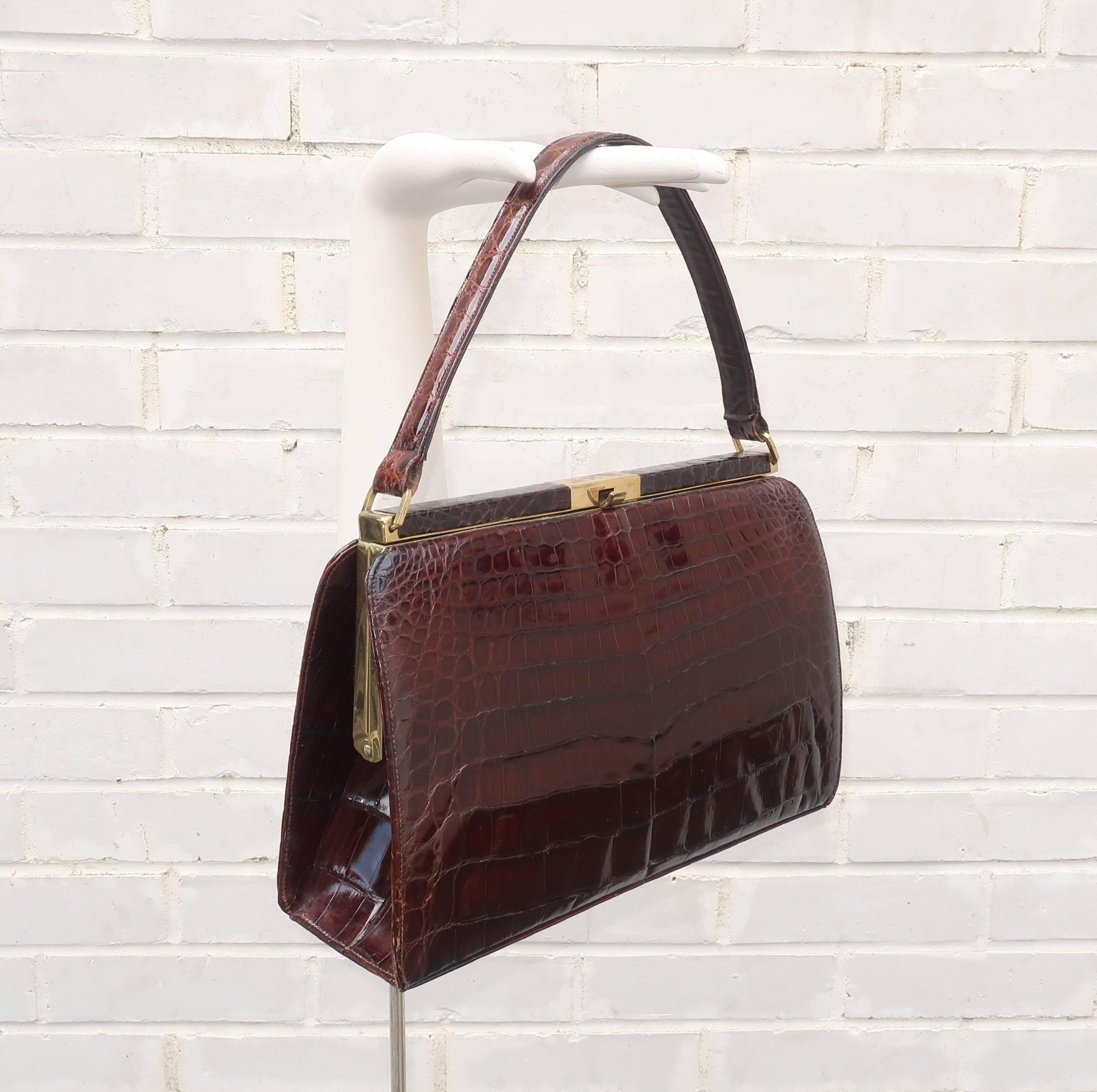 This 1950’s Bellestone brown alligator handbag would be perfect for an Alfred Hitchcock heroine ... think Grace Kelly, Tippi Hedren or Kim Novak. The classic top handle silhouette has a brass frame with a push button closure accented with an