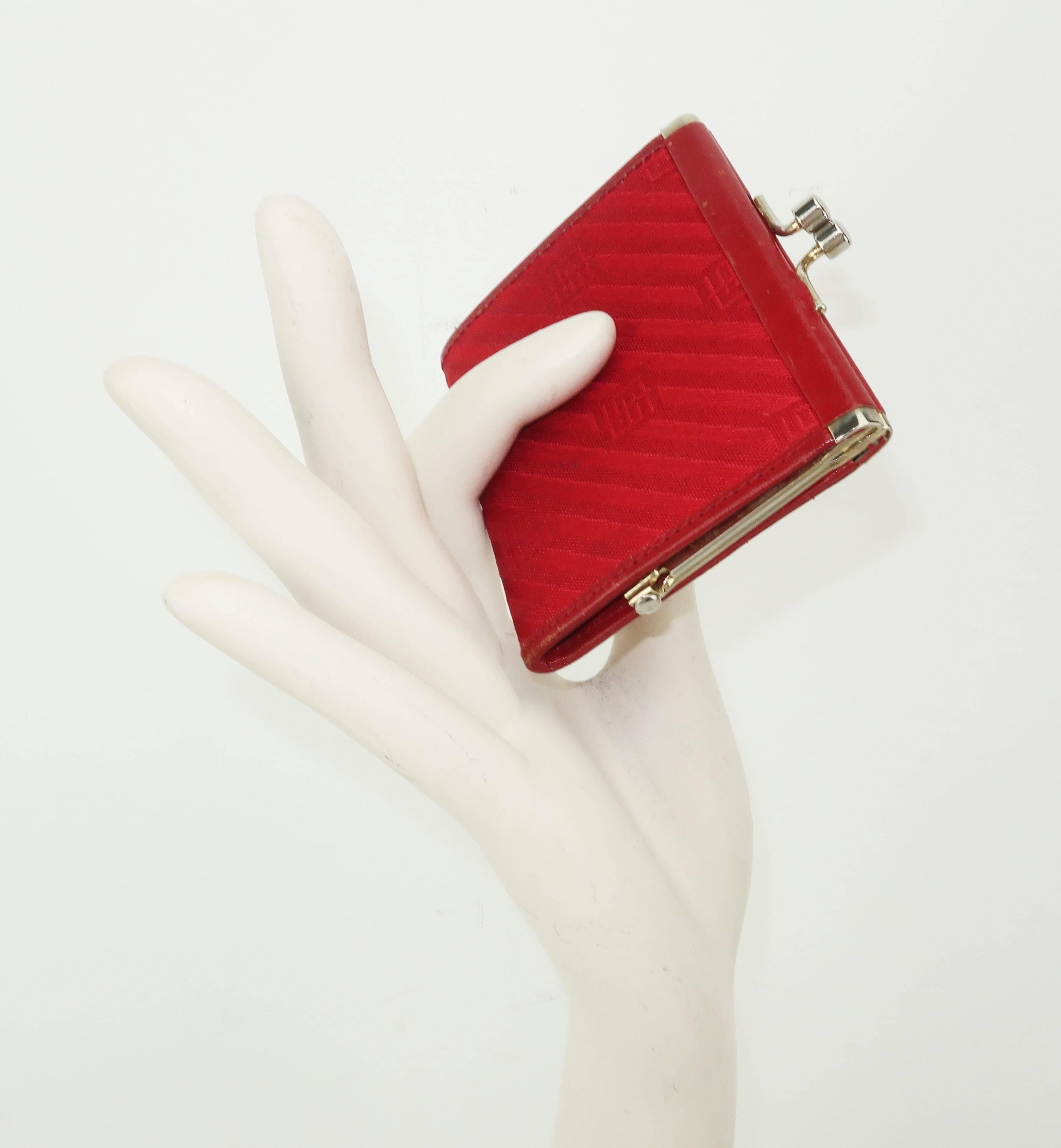 Emilio Pucci, a name synonymous with the mod prints that first hit the fashion world in the 1950's, produced this red leather edged change purse using a durable striped jacquard fabric.  The jacquard stripes are set on a diagonal with a geometric
