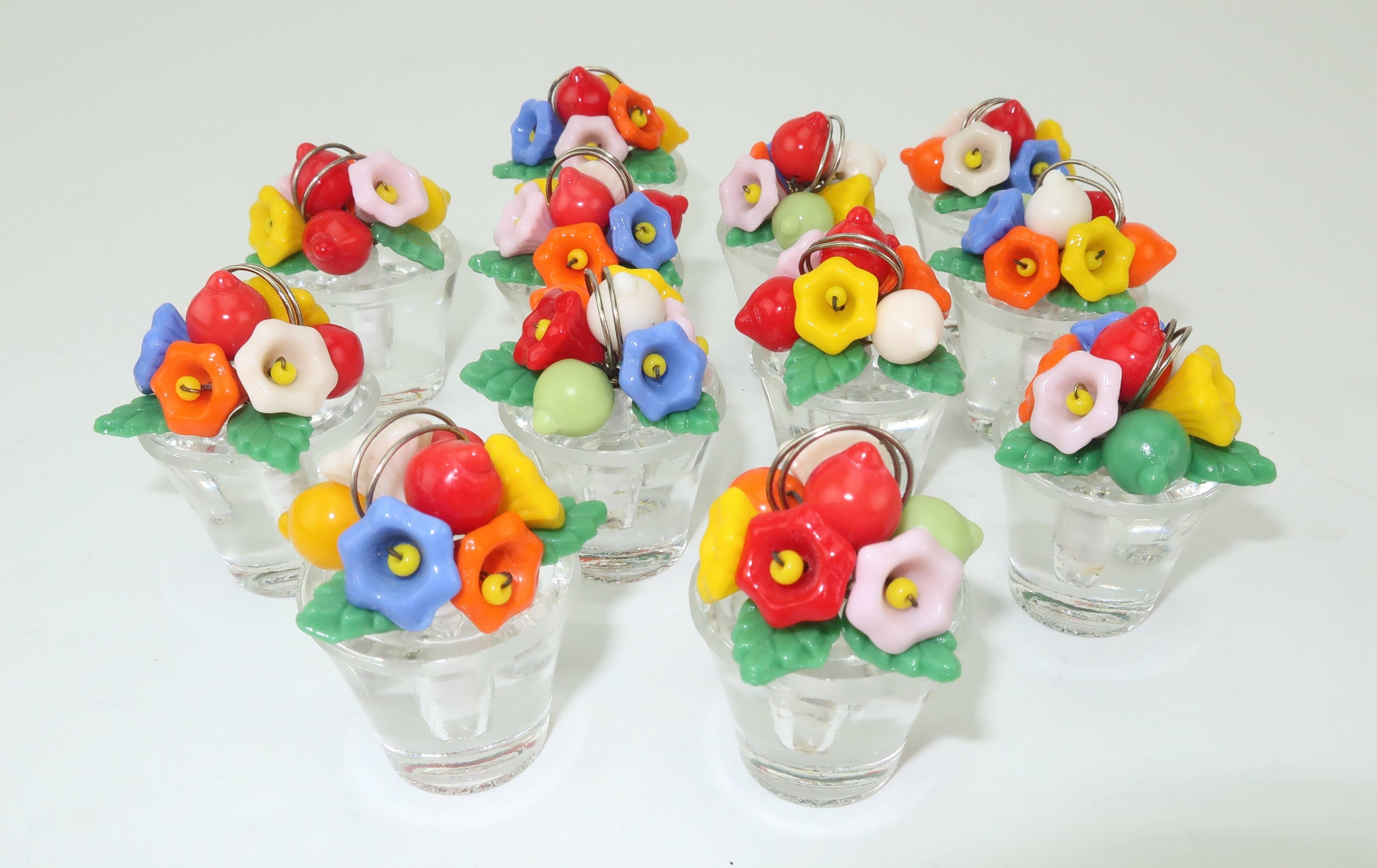 These precious potted bouquets are perfect for a bright and summery table setting.  Each of the twelve place card holders are fabricated from 1920’s Czecoslovakian glass and feature a clear container topped with red, yellow, pink, orange and blue