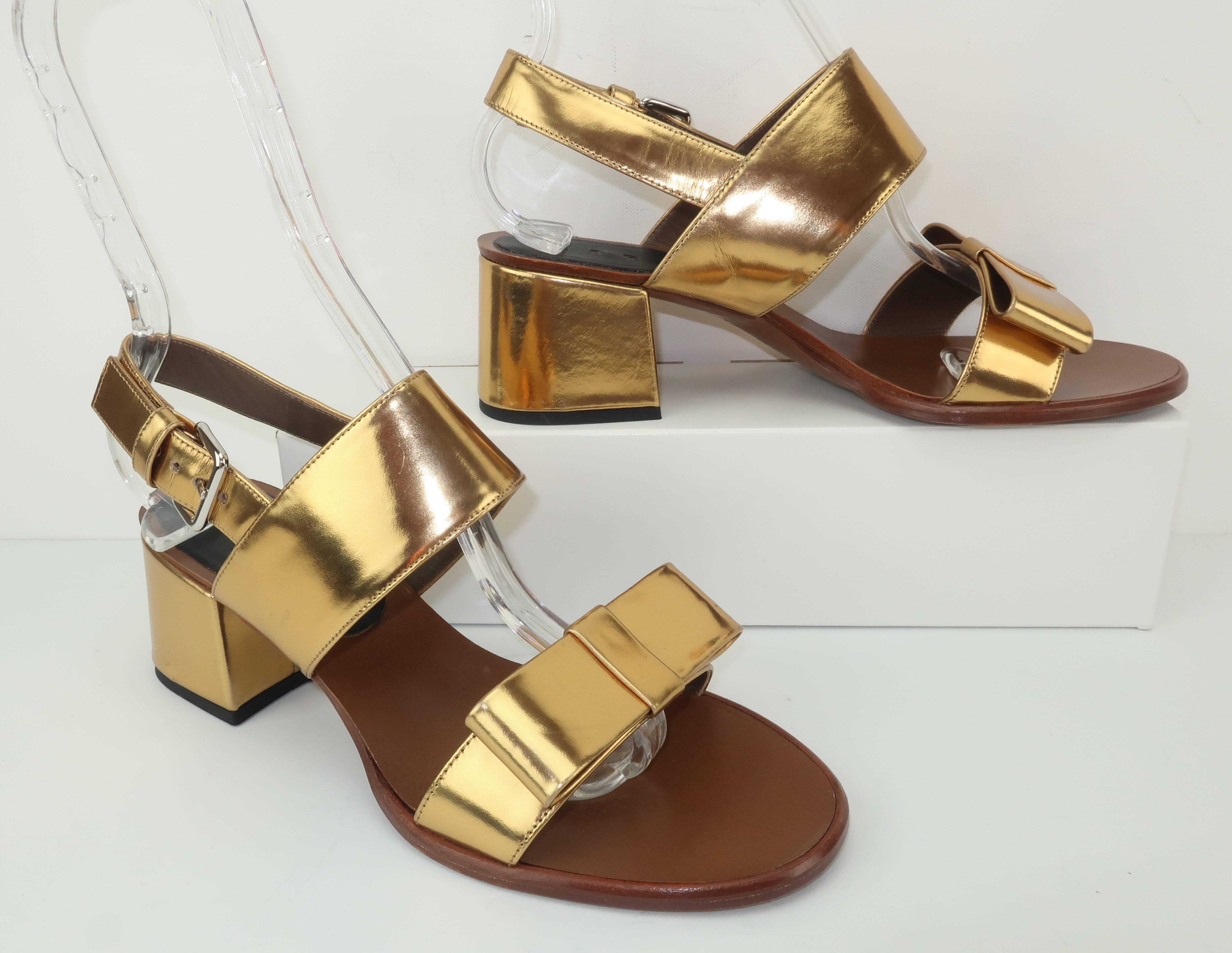 This low heeled sandal by Marni is a fashionable combination of practicality and frivolity.  The gold leather body has a 1960's style silhouette with an adjustable slingback strap and a girlish bow embellishment.  The 2.25