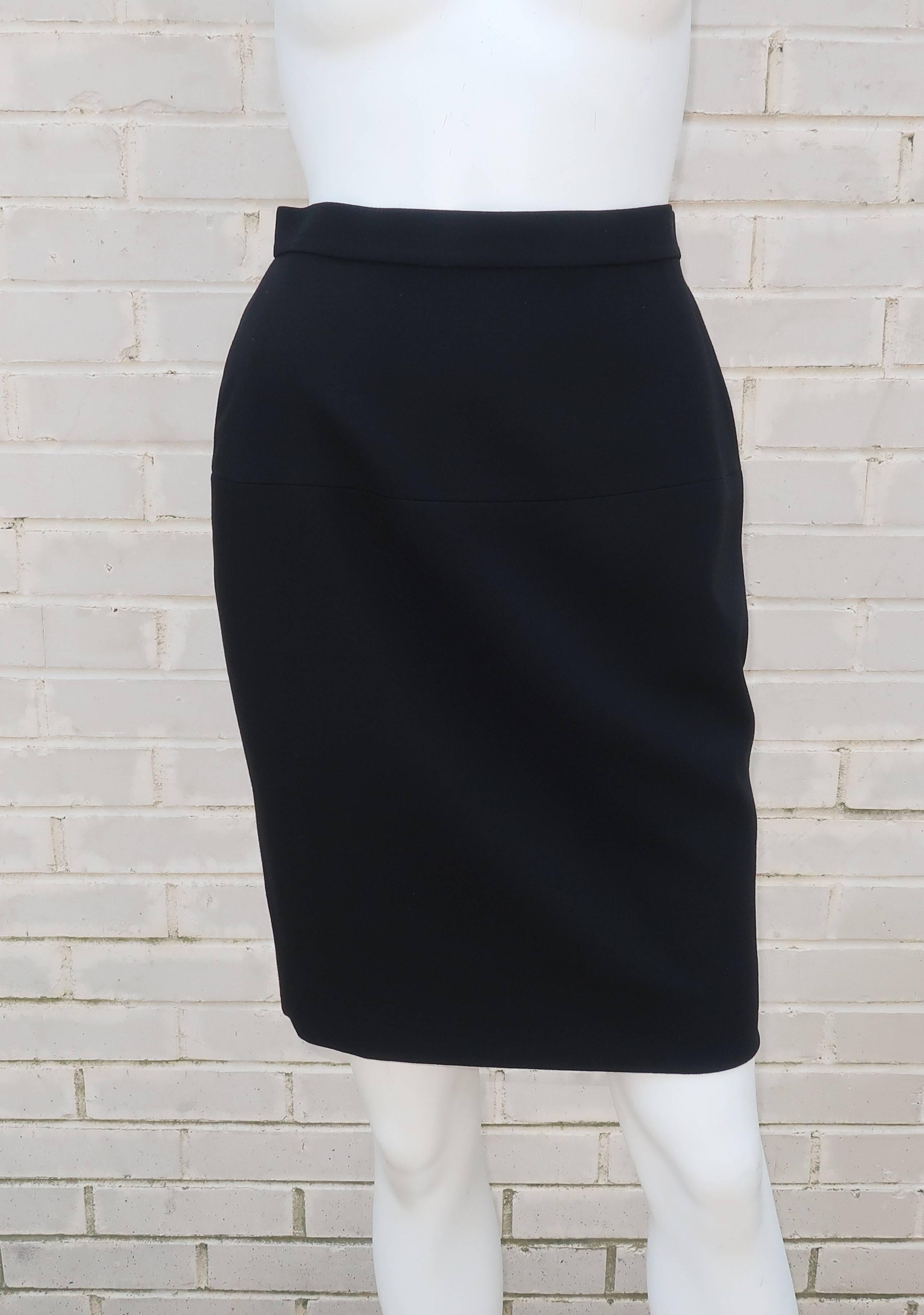 This classic Chanel black skirt knows no seasons and can be worn to achieve many looks all year long.  The skirt zips and buttons at the back with a gold tone Chanel 'CC' logo button at the waistband.  For added interest, there is a subtle skirt