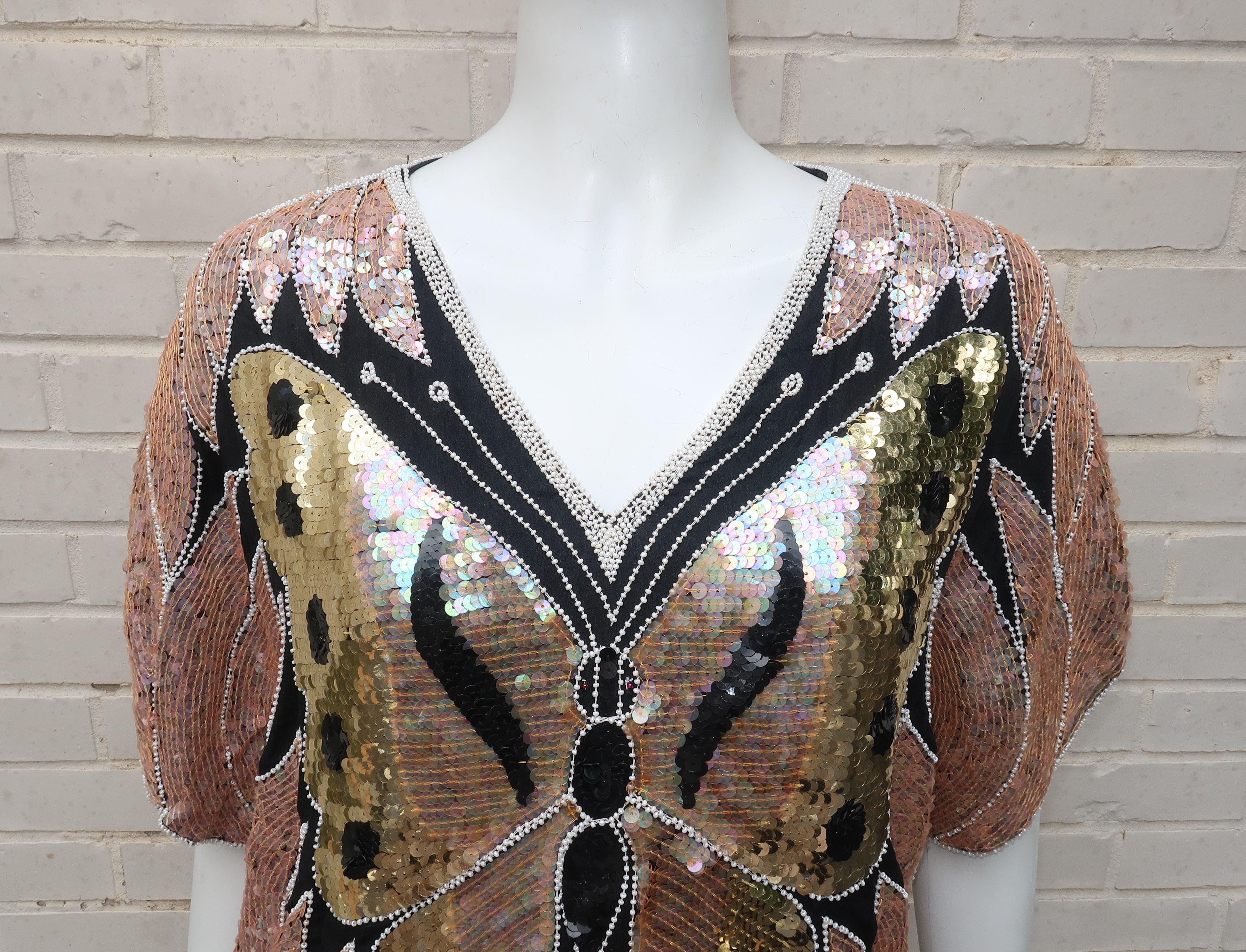 Transform yourself with a sequin touch!  This 1970's pullover top by Shomax is an fun piece of wearable art.  The lined black silk fabric background serves as a canvas for the well placed pale pink, gold, black and iridescent sequins.  Pearl seed