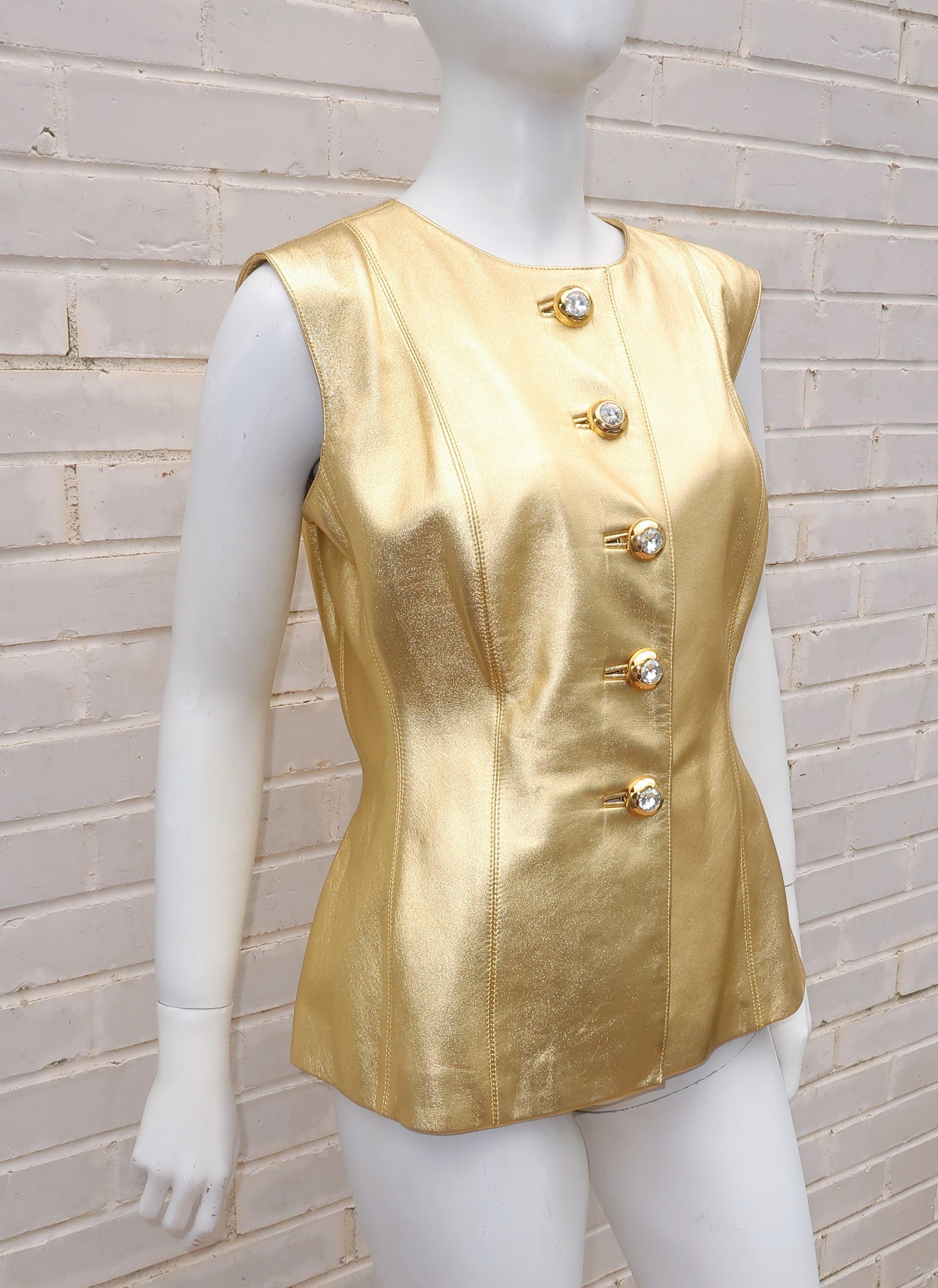 Go all space age with this 1980's Yves Saint Laurent Rive Gauche bright gold leather waistcoat style vest with large rhinestone buttons.  The vest has exposed vertical stitched panels and a nipped waist all creating a glam rock image perfect paired