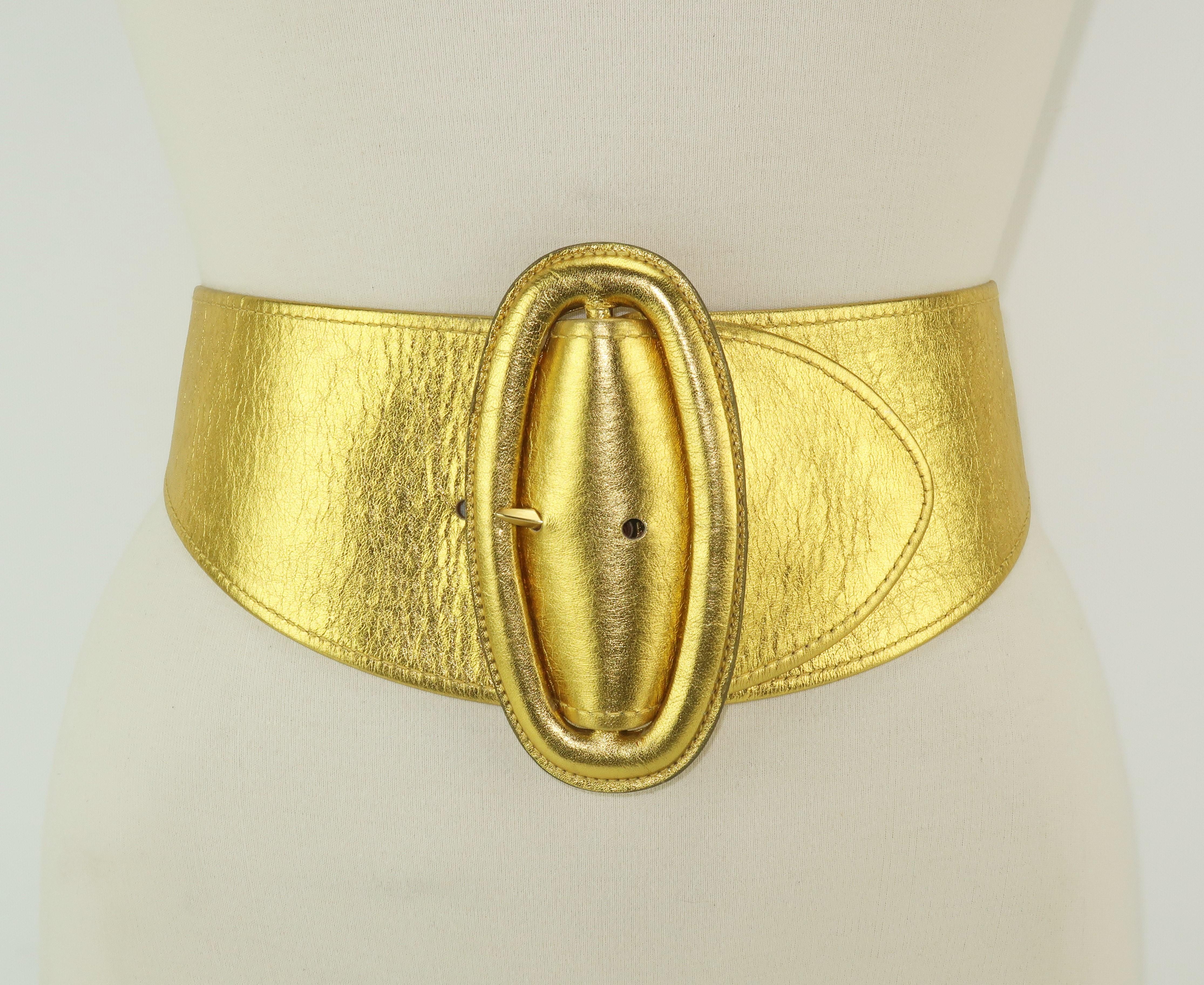 Be a fashionable superhero with this large-and-in-charge gold leather belt from Donna Karan.  The sculptural silhouette accents the elongated oval buckle which tapers at the back.  Marked a size 'Small' and made in Italy ... a true wardrobe