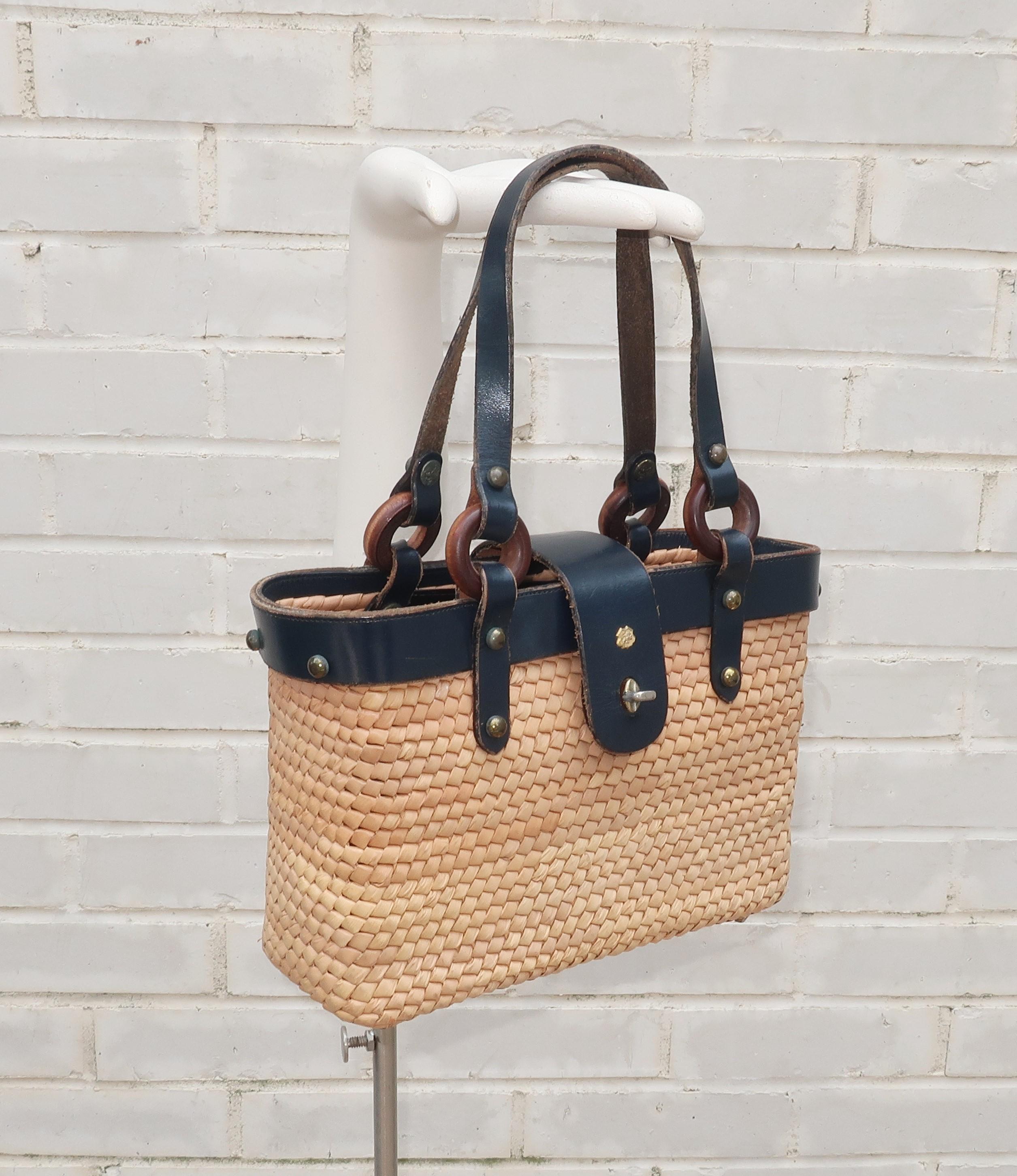 John Romain handbags are an American classic. In the 1960's and 1970's, the iconic tweed and leather designs were on the arms of preppy coeds from coast to coast. This straw handbag was designed as part of a late 1960's collection to introduce a