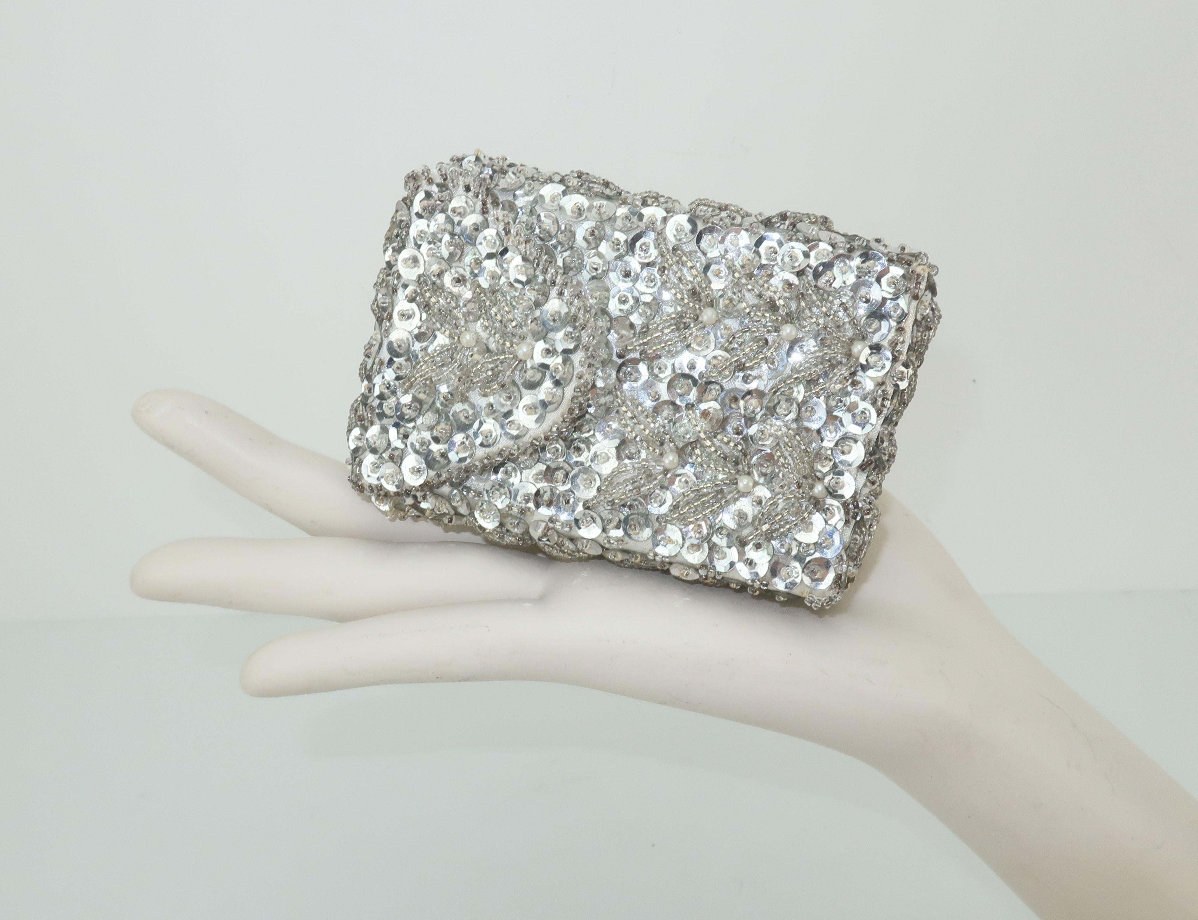 Hilde Walborg founded her company in the 1940's and was always in search of the best handmade beading for her designs.  This fully embellished silver sequined cigarette case has a white satin fabric base accented with silvery seed beads and tiny