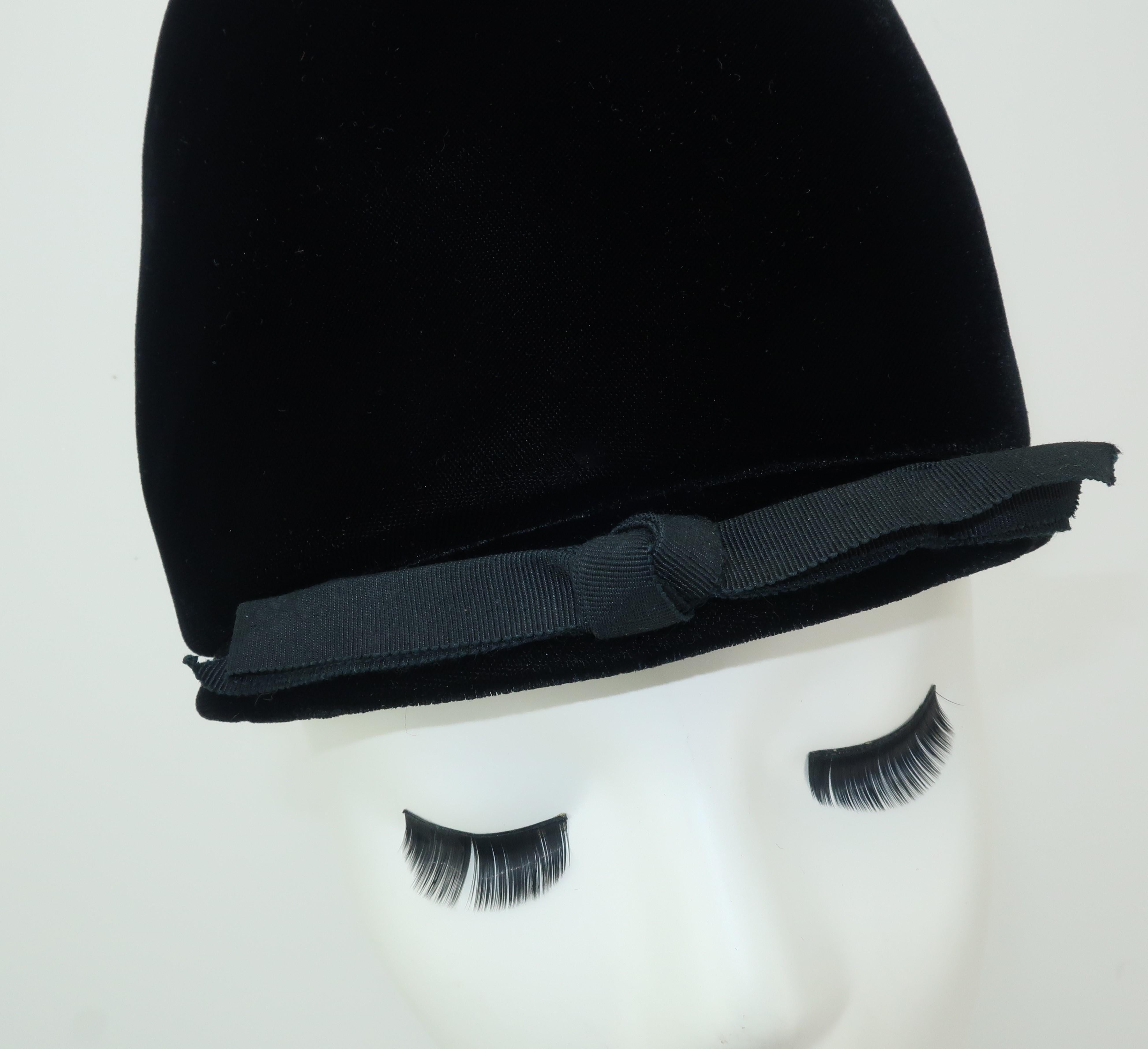 The silhouette of this tall Franklin Simon velvet helmet hat is the epitome of 1960's mod fashion.  Just imagine it paired with an a-line dress, matching tights and buckled shoes or mix it with plaids and deconstructed coats for a current trend. 