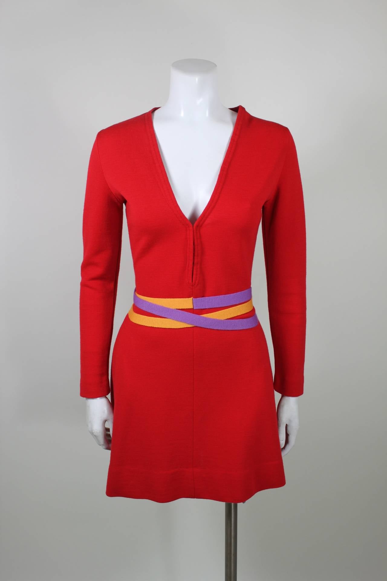 This is a wonderful minidress from iconic 1960s designer Rudi Gernreich. Done in the designer's signature wool colorblocking, the dress features a yellow and purple attached wrap belt. A deep v-neck bodice is just the right amount of sexy. Please