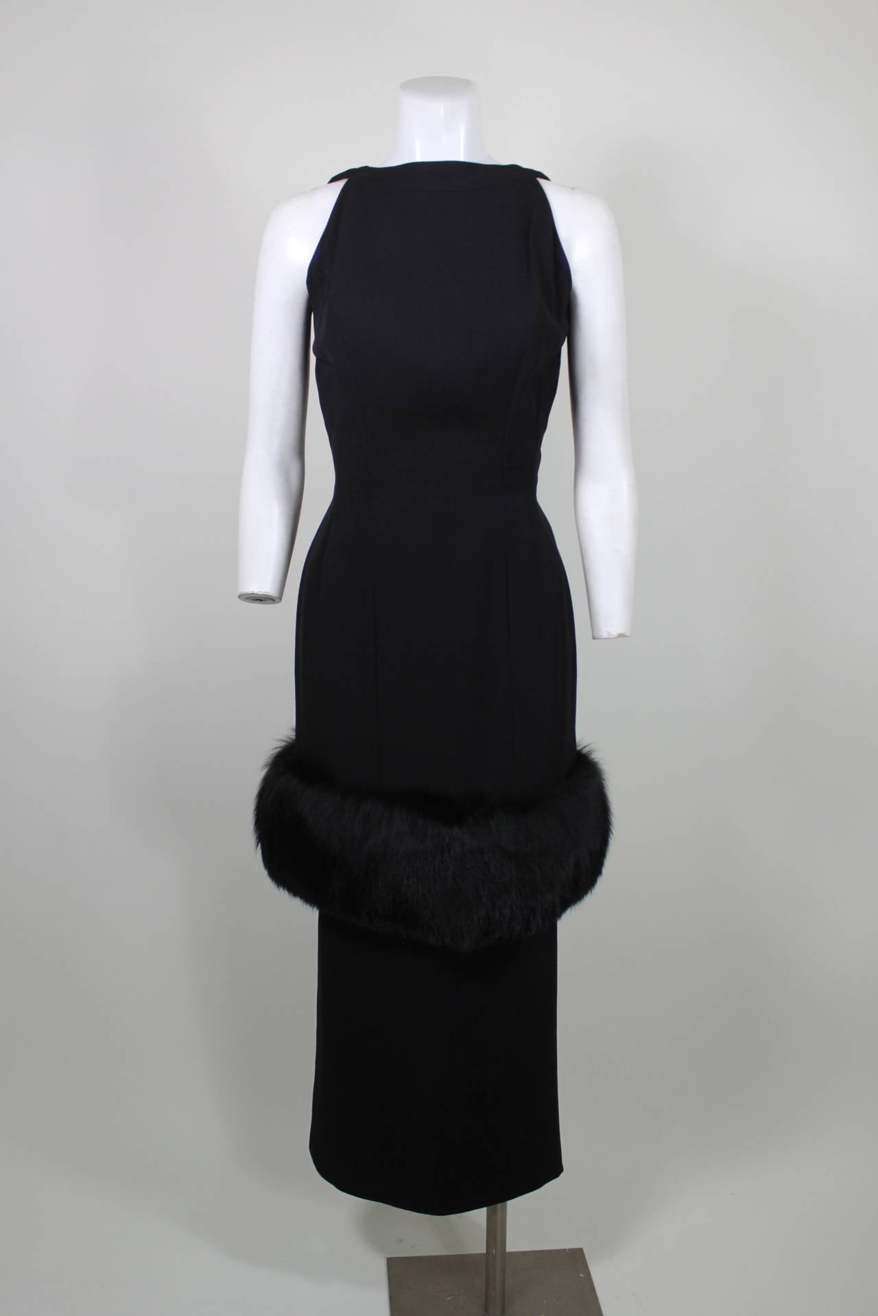 A gorgeous two-piece evening ensemble from the 1960s. Done in gorgeously tailored wool, the sleeveless bodice features a lux fur trim that hits just below the hip. A high-waist midi pencil skirt accompanies the ensemble for a longer silhouette.