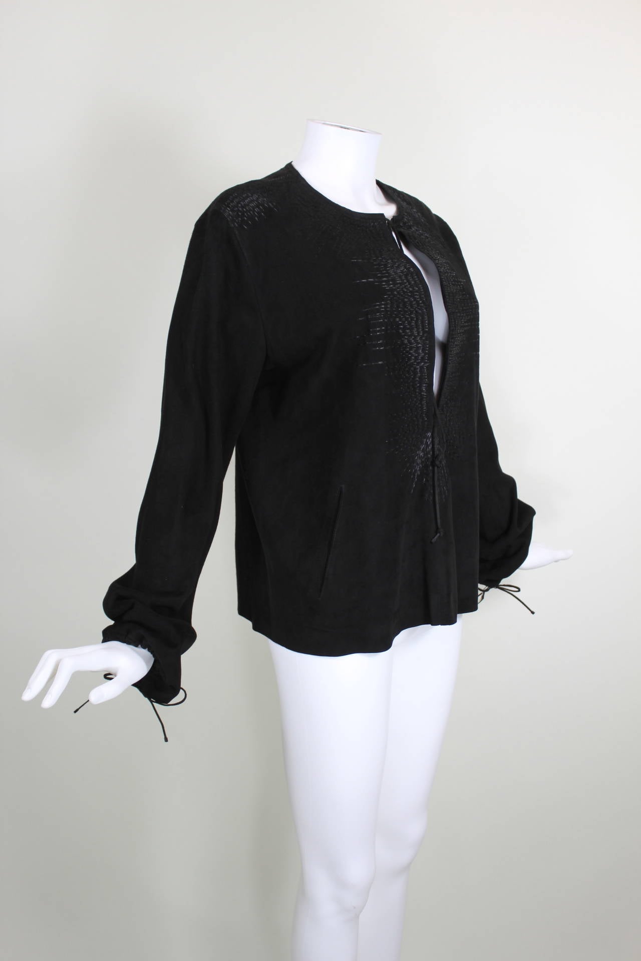 A luxe suede tunic from Gucci embellished with black metallic embroidery throughout. The tunic features a sexy deep-v that ties at the neck, gathered sleeves, and two pockets in the center. Unlined.

Measurements--
Labeled a size 44
Bust: up to