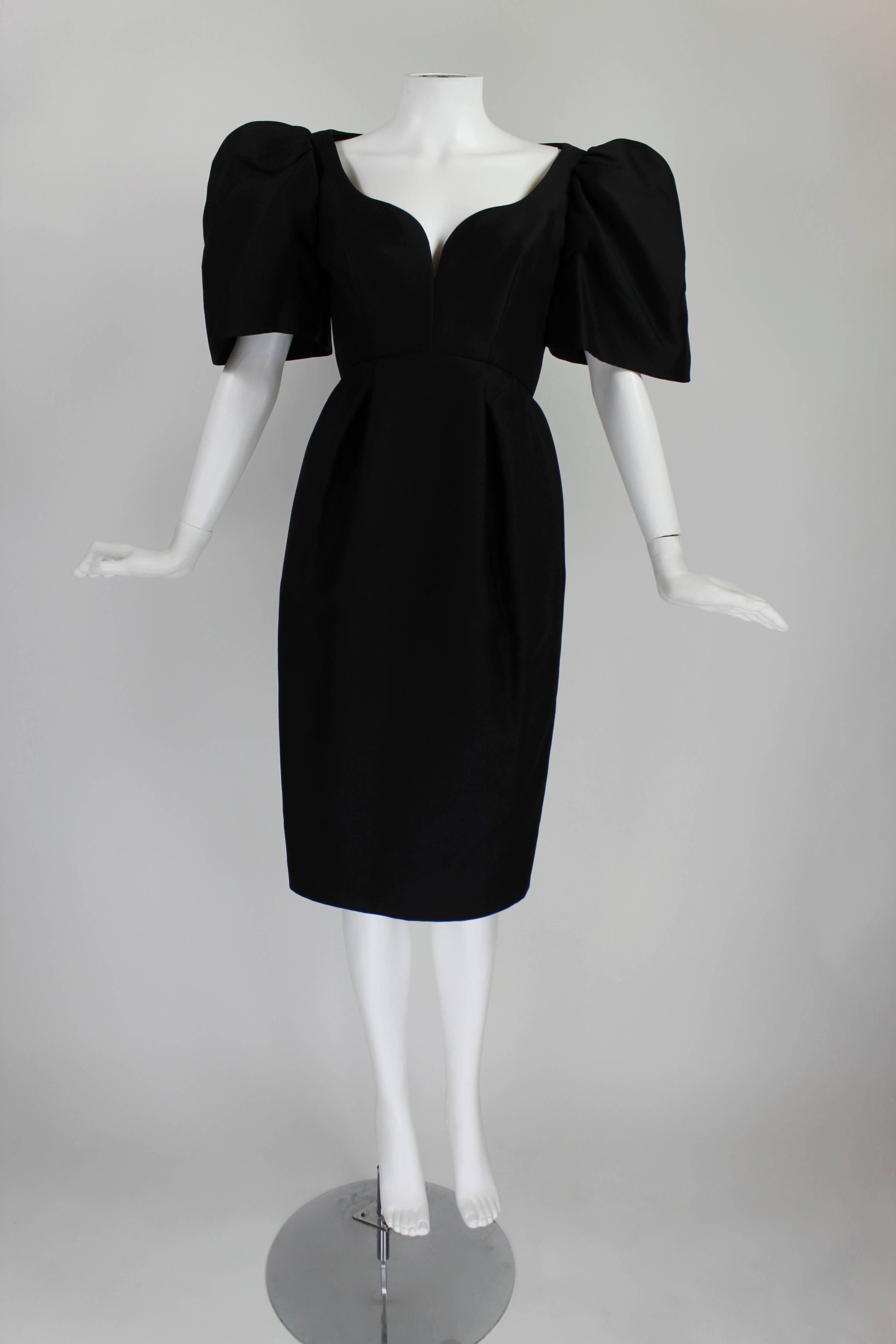 This absolutely stunning cocktail dress from Galanos features beautiful tailoring combined with an interesting, unique silhouette. The strong, tall bell sleeves are balanced by a nipped waist and tulip-shaped hip pleats. 

-Fully lined
-Zips in