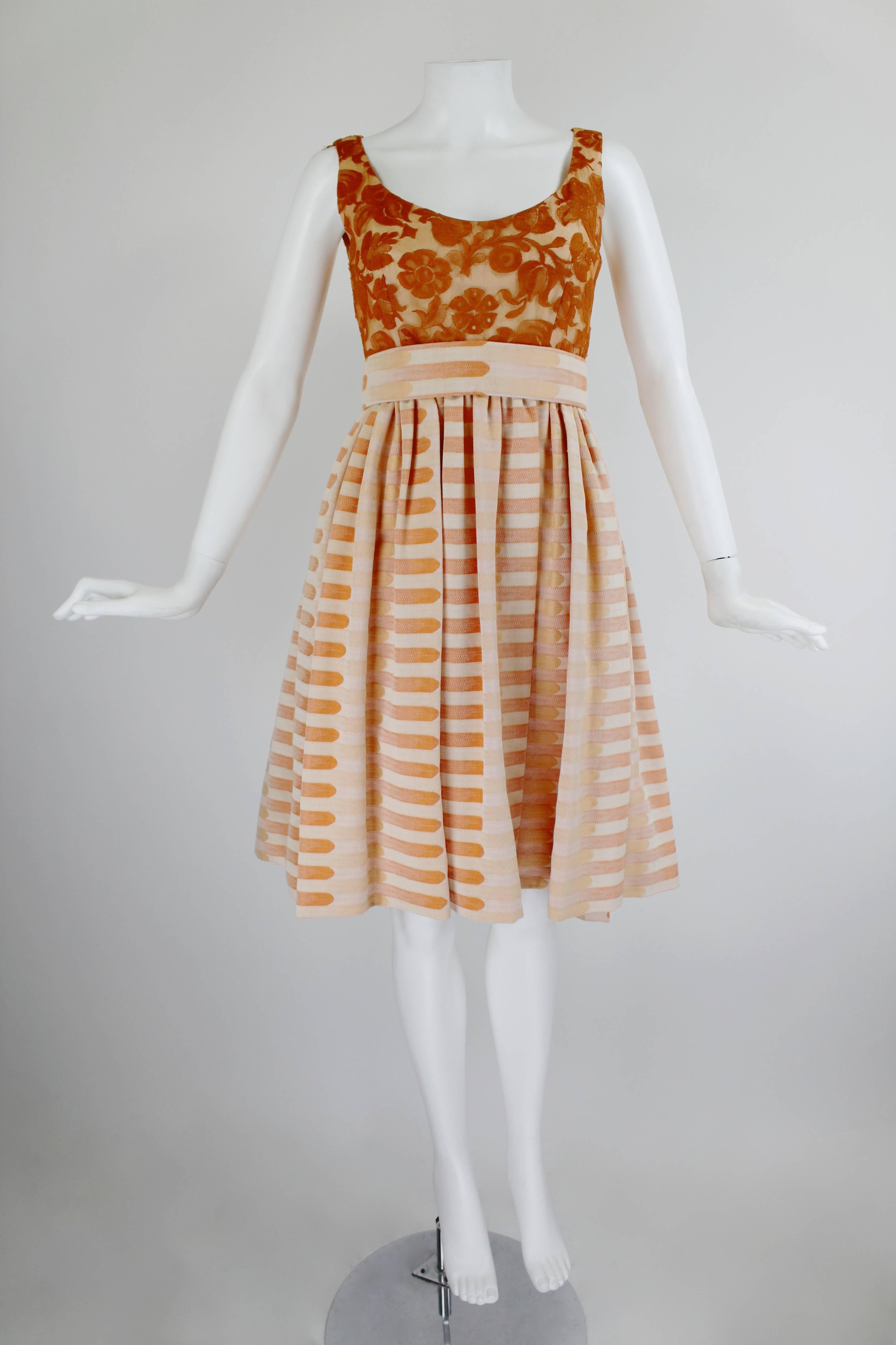 The skirt of this fabulous Amey ensemble is done in the most beautiful peach and tangerine colors, woven in a graphic horizontal print. Pumpkin orange lace covers the bodice, and the dress has a matching lace jacket with pearl pumpkin