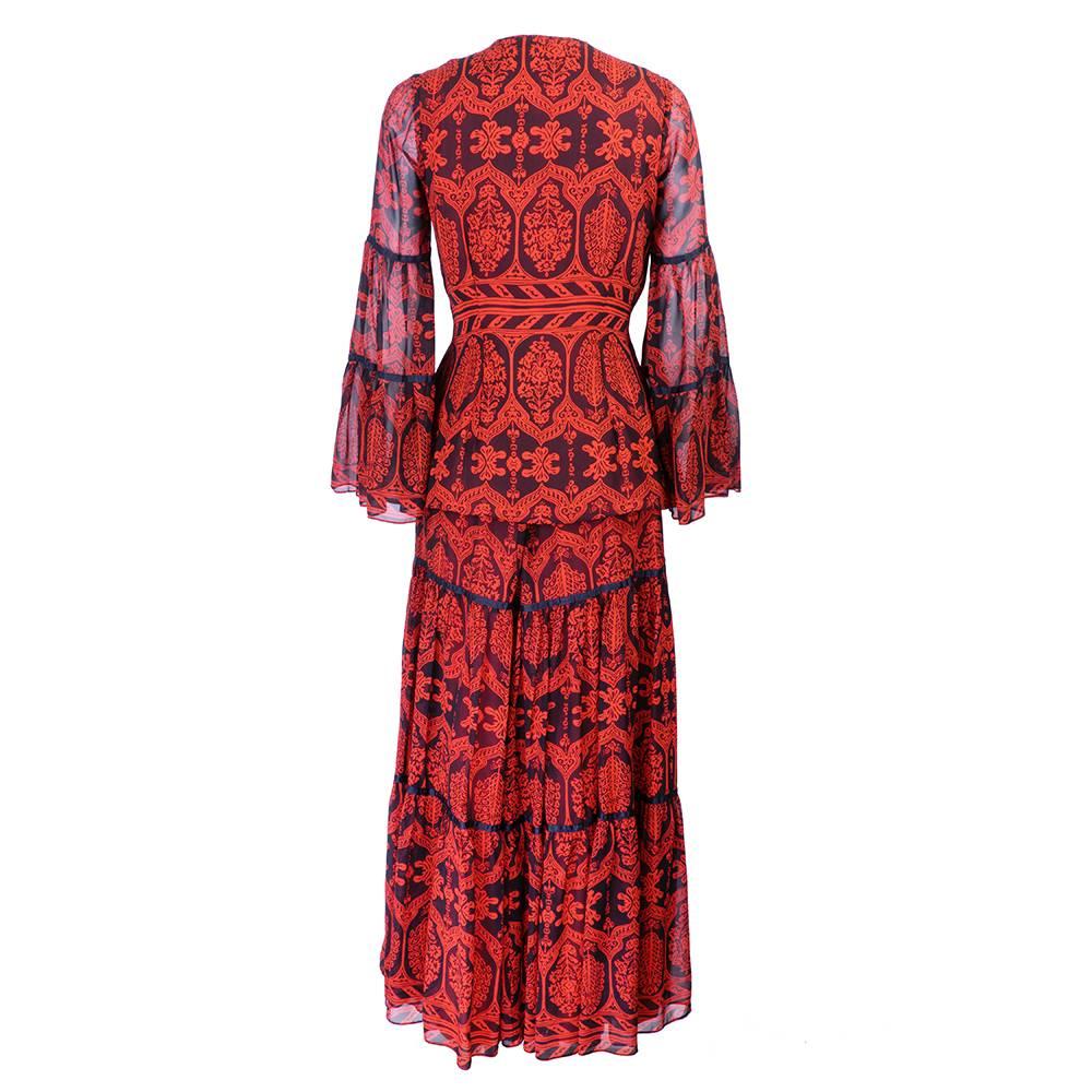 Jacket and blouse ensemble in wood-block style print. High neck, button-down. Flared hem and cuffs. Thin silk panels on sleeves. Covered buttons. Peasant-style and tiered long skirt. Matching black silk panels. Side zip closure. 

Jacket