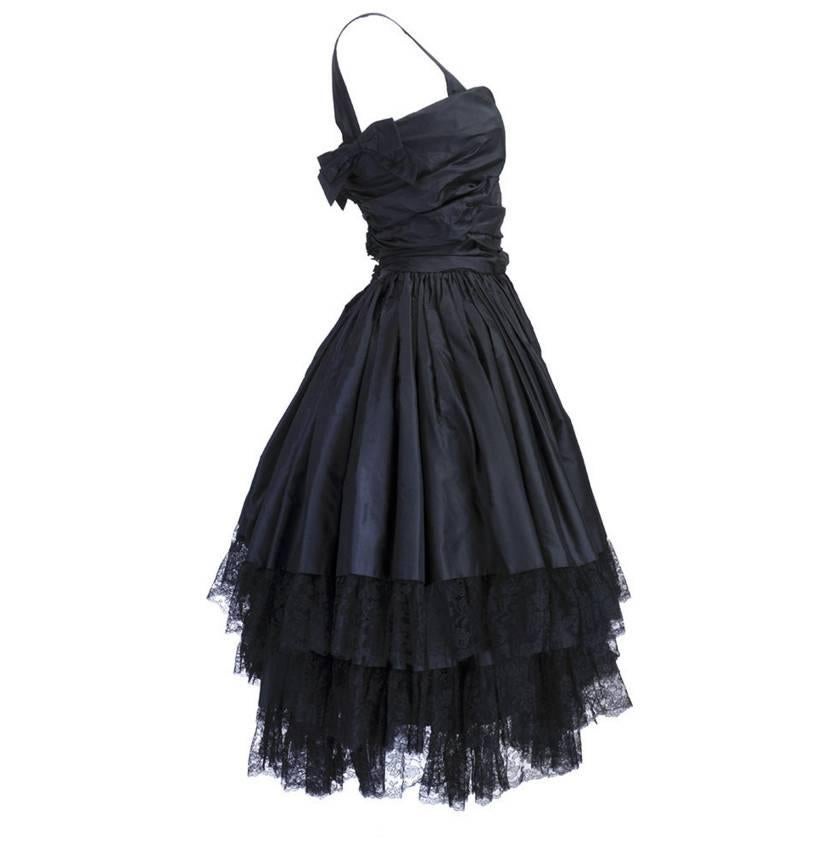 Black silk taffeta. Fit-n-flare silhouette. Lace trim. Ruched bodice. Full petticoat. Built-in zipper corset. Bow detail. Zipper back. Excellent condition. 

Bust: 32