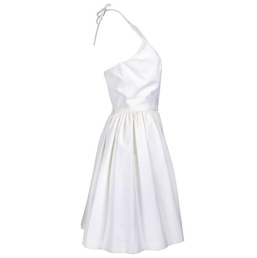 White piqué halter dress. Halter with flared skirt. Tie-neck. Back zipper. 100% cotton. Excellent condition.

Bust: 34