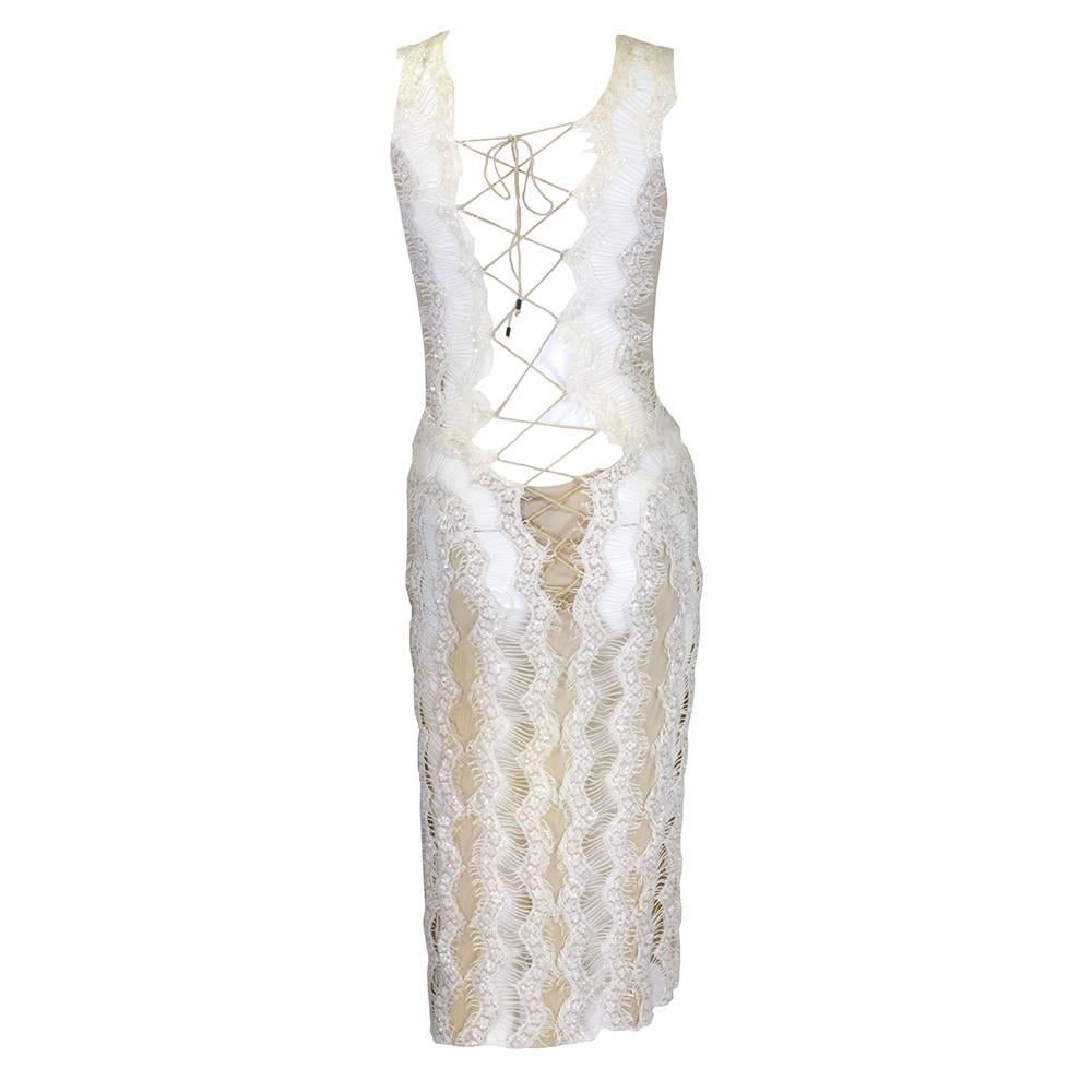 Gianfranco Ferre is, arguably, the master of sexy, chic illusion silhouettes. This gorgeous cocktail dress is done in nude silk jersey with vertical strips of sequined white lace enhancing the silhouette. A sexy criss-cross cord goes up the front