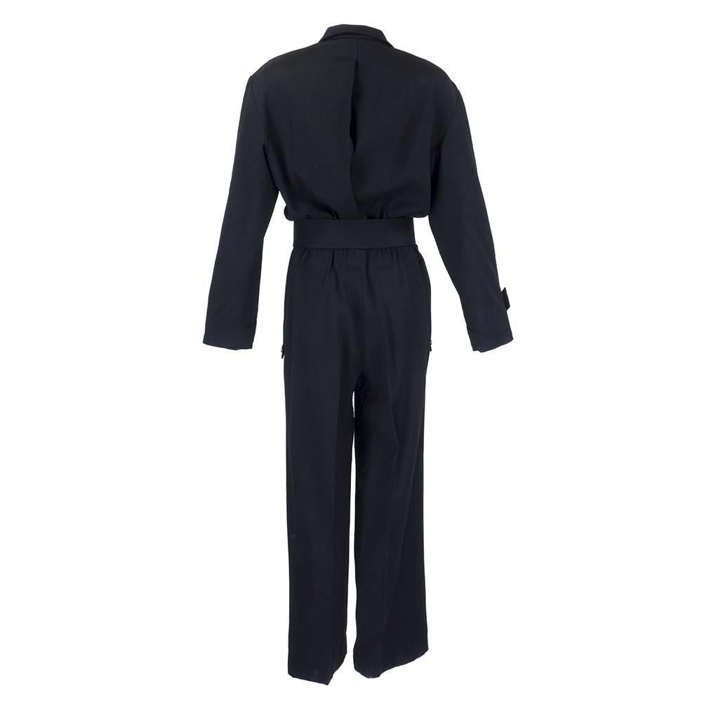 1980's Thierry Mugler all wool classic jumpsuit with exaggerated features including power padded shoulders, exaggerated collar and matching wide belt. High waisted with wide leg, front flap pockets and star snap closures.