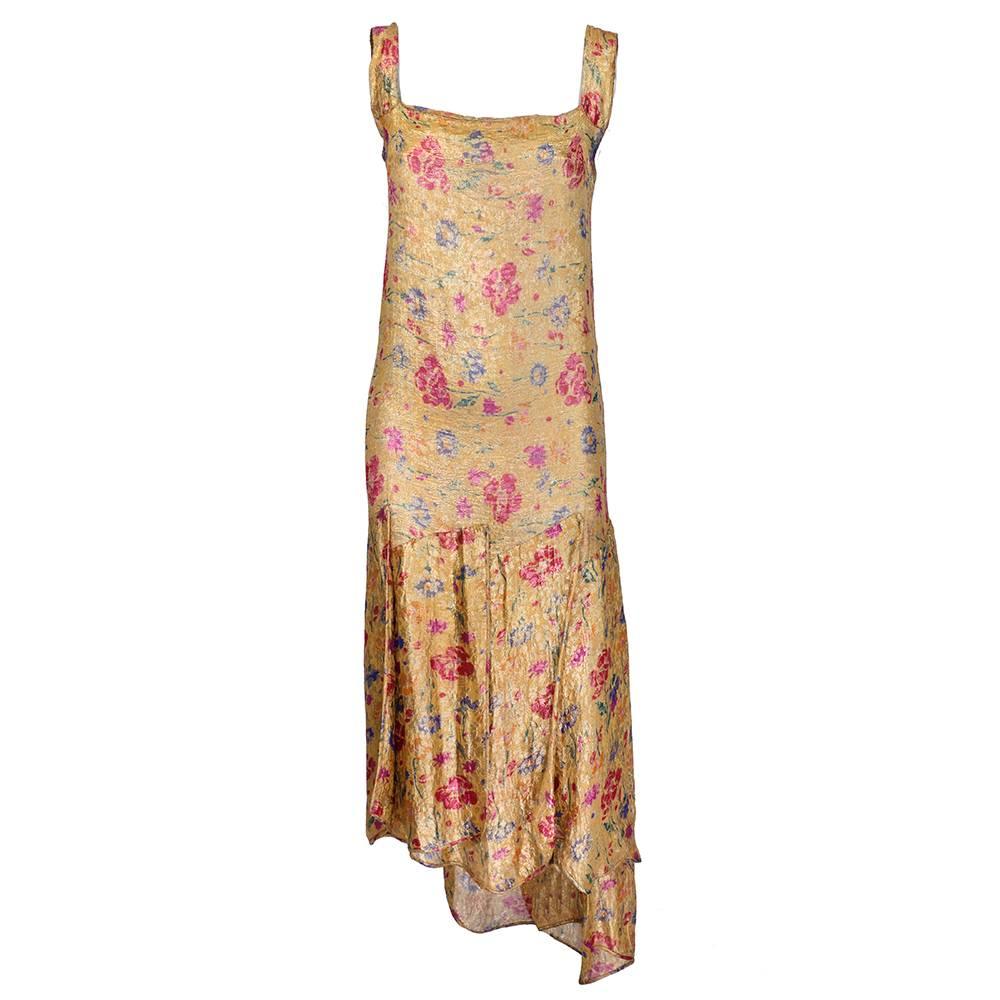 Stunning and dramatic French 1930s gold lame asymmetrical draped gown with floral print.  Dropped waist with flounced petalled skirt that are extra long at back of skirt.