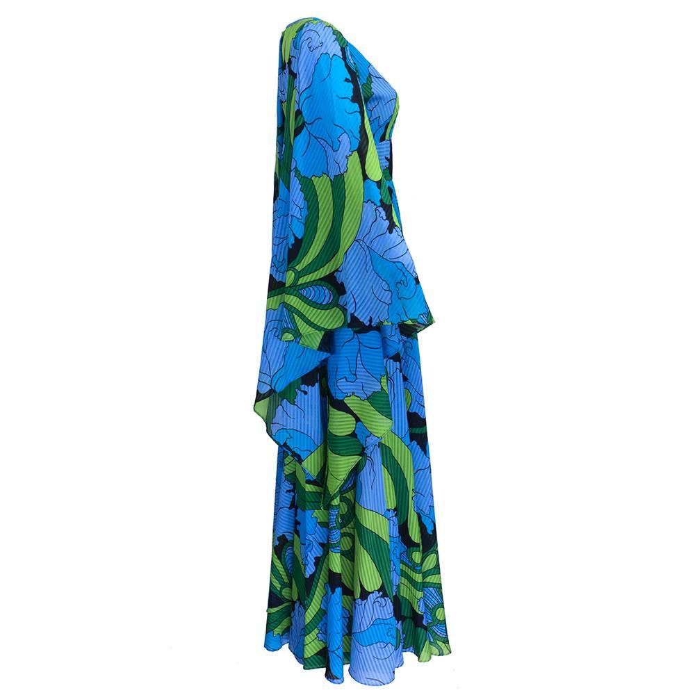 1970s full length dress in shades of blue and green with oversized abstract botanical print.  V-neck with self tie waist and exaggerated drop bell sleeves. Full skirt. Cotton blend with rayon acetate lining.