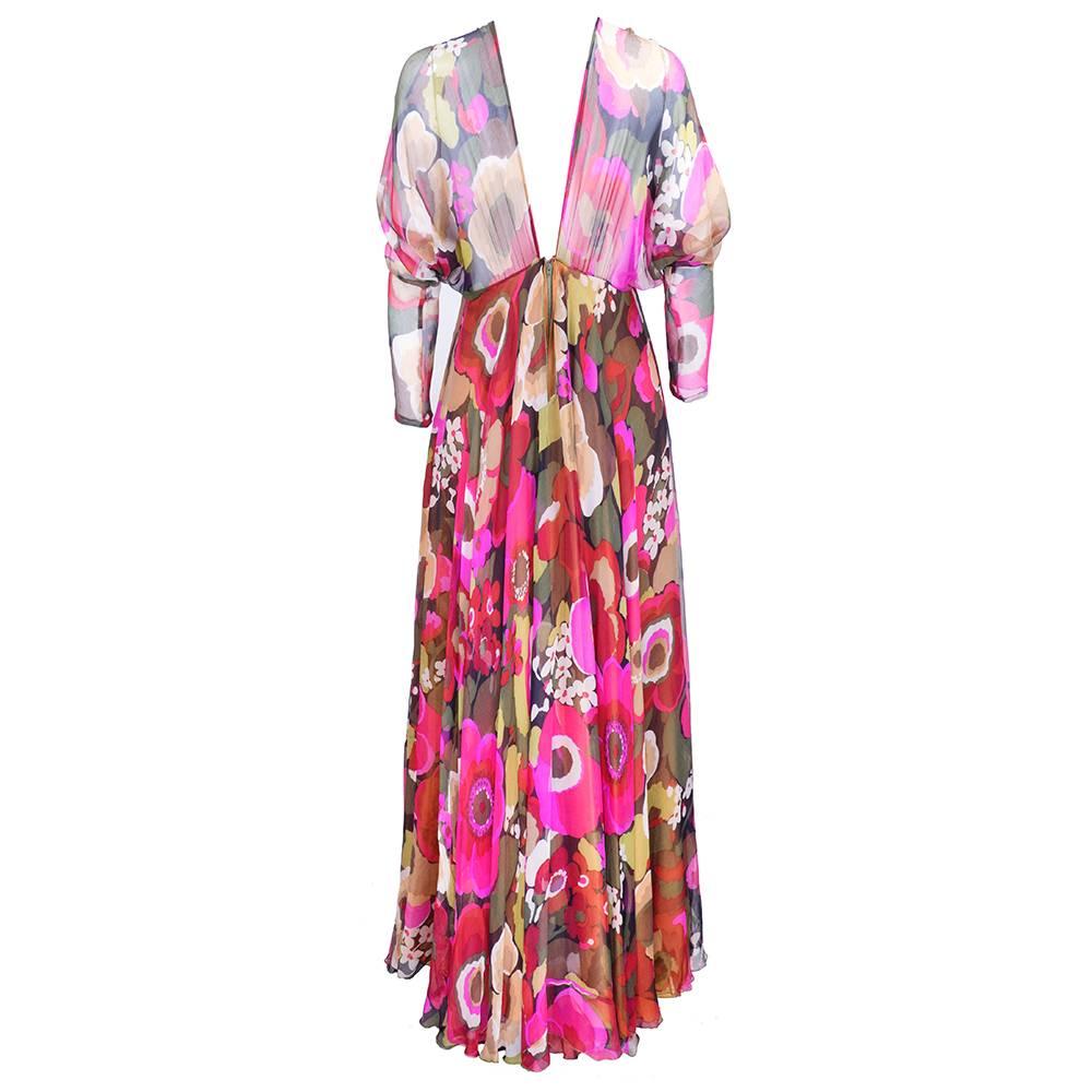 Wonderful 1970s silk chiffon gown with op art floral print by iconic British designer Yuki.  Drop sleeves with full sweeping skirt. Fully lined. Deep V back.