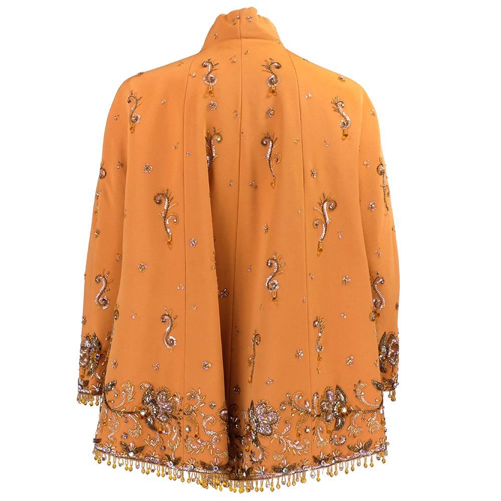 Lush, heavily embellished unlabeled pumpkin hued evening jacket. Draped, semi-swing silhouette. Fully lined with flourished beading and sequins. Hem is weighted and fringed with beads. Super stunner!