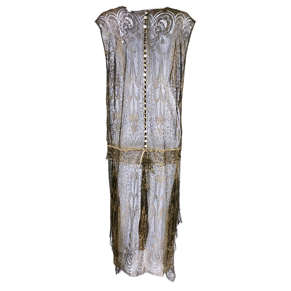 A stunning 1920s dress of gold bullion lace with a lovely burnished patina. Drop waisted with a tabard style top and wonderfully draped side panels on skirt. More than likely French.  Gold buttons down back from neck to waist. A true showstopper.