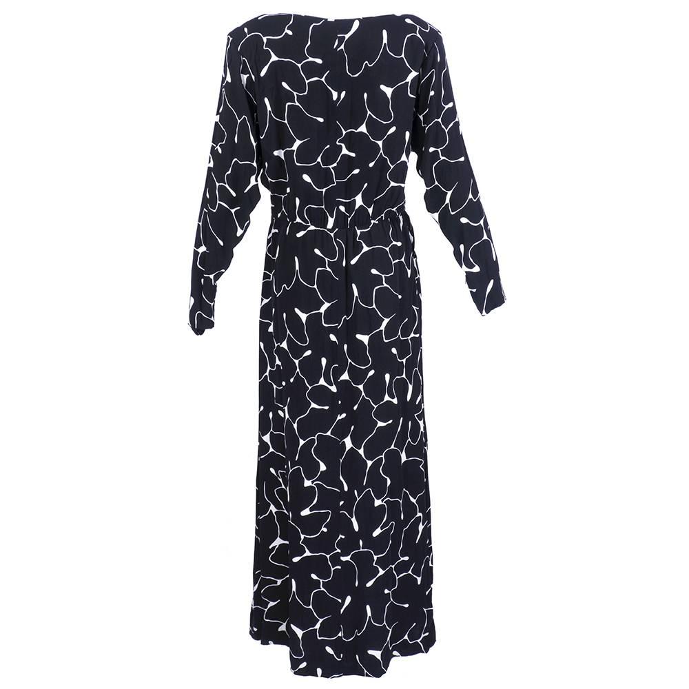 Black and white graphic print rayon crepe gown for the Saint Laurent Rive Gauche label circa 1980s. Classic styling with hight neck, long sleeves, fitted waist and hip pockets. Zips up the side and is half lined.