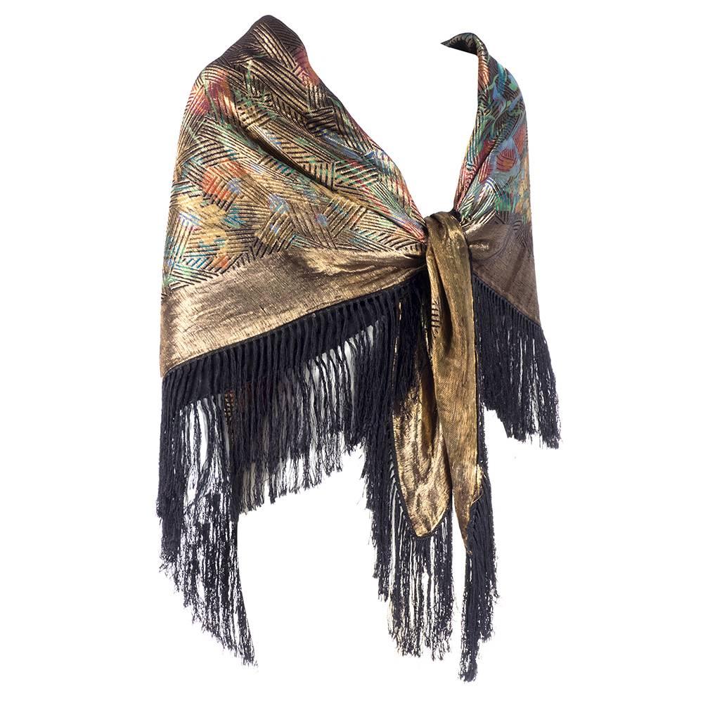 Gorgeous 1920s shawl with a deco floral print in gold lame with knotted fringe. 

Fringe: 5