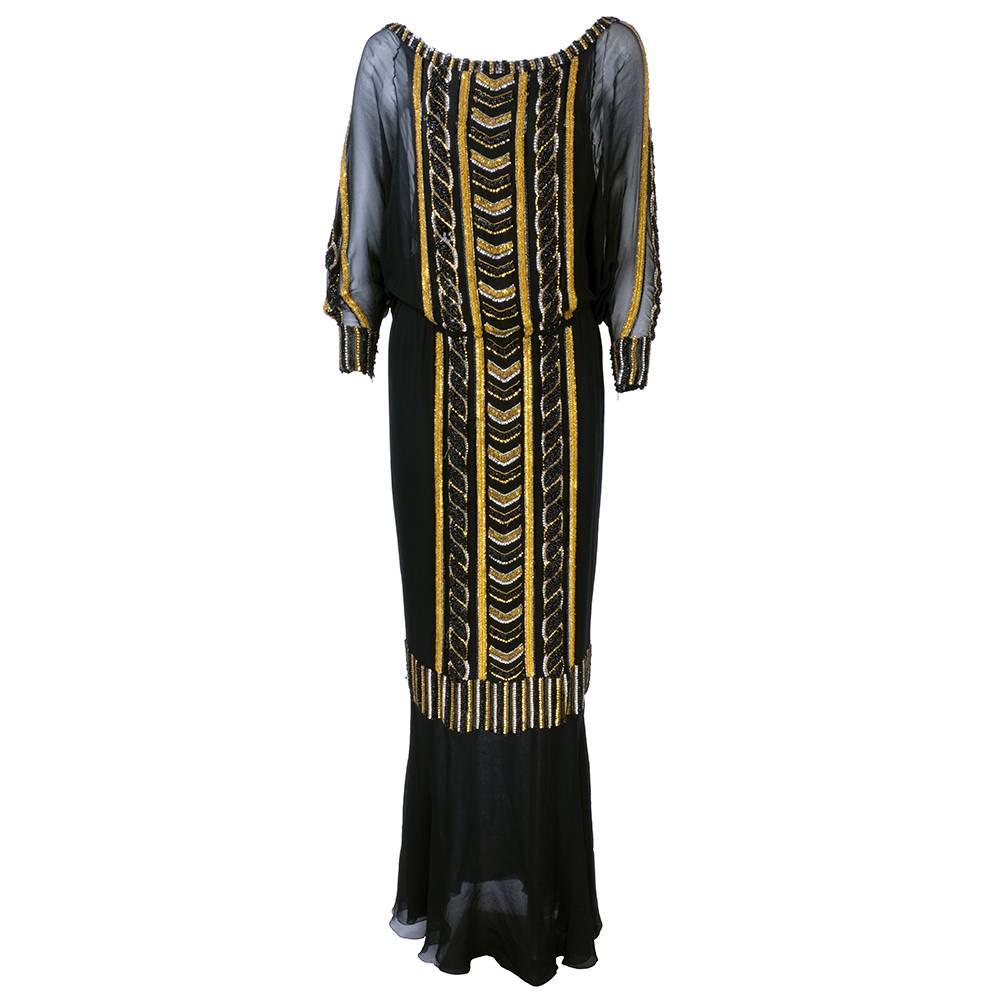 Museum attributed Mark Bohan for Christian Dior 1980s gown heavily beaded in gold, black and beaded. Multi-layered with dropped dolman sleeves. Full length with long sleeves that zip at cuff. Flounced hem. Dated 1985.